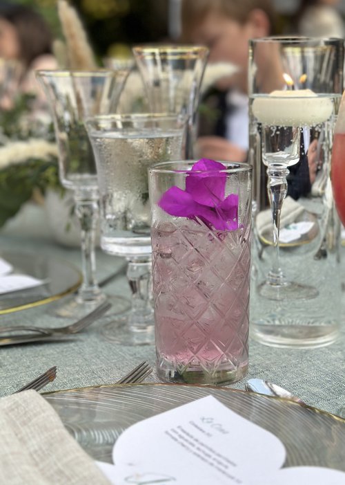 Cóctel rosado con una orquídea fucsia sobre la mesa