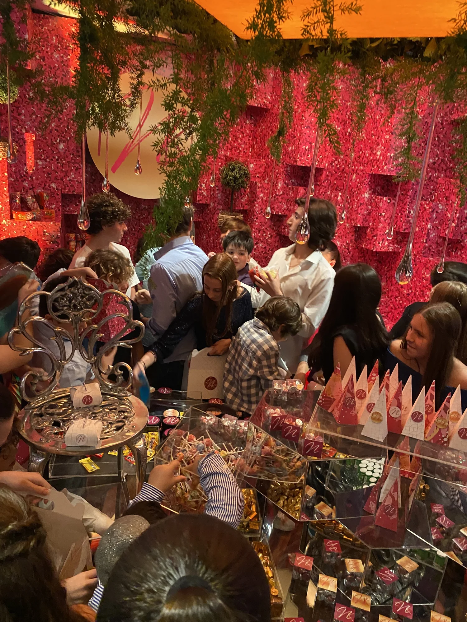 Invitados frente a la mesa de dulces con decoración roja