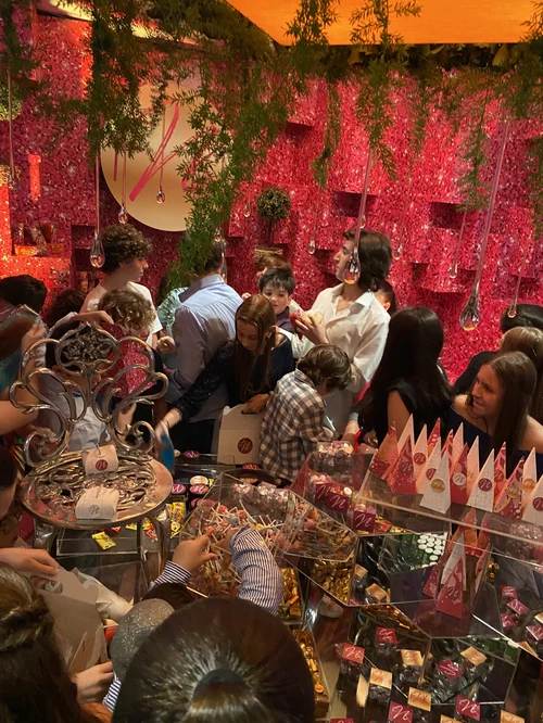 Invitados frente a la mesa de dulces con decoración roja