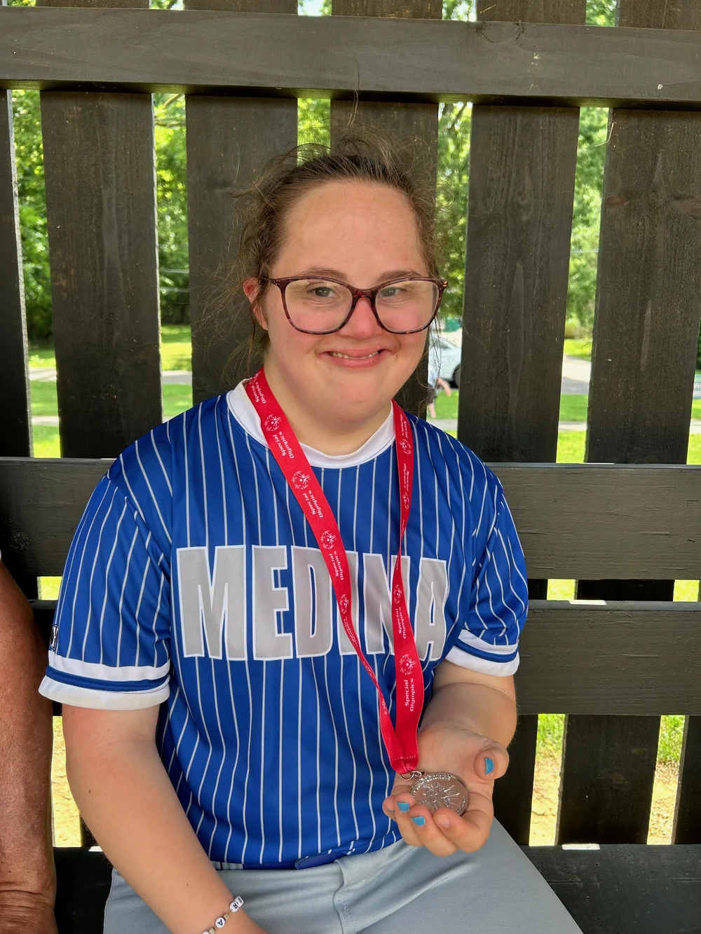 A Flash athlete in a Medina jersey with her medal.