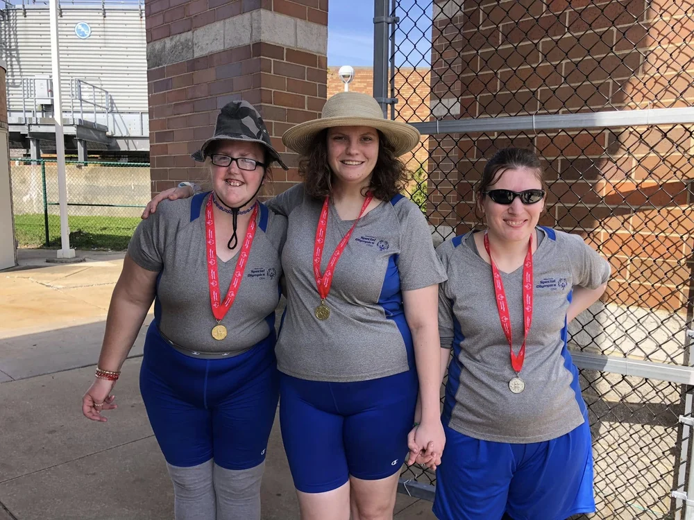 Three Flash athletes wearing their medals at the ballpark.