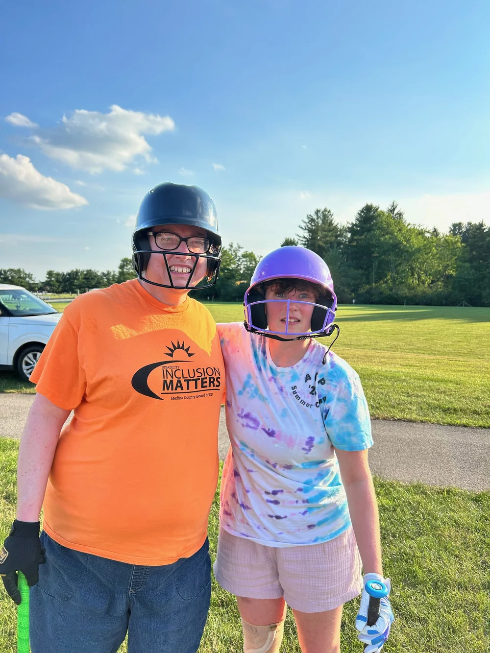 Two Flash softball teammates in their batting helmets.