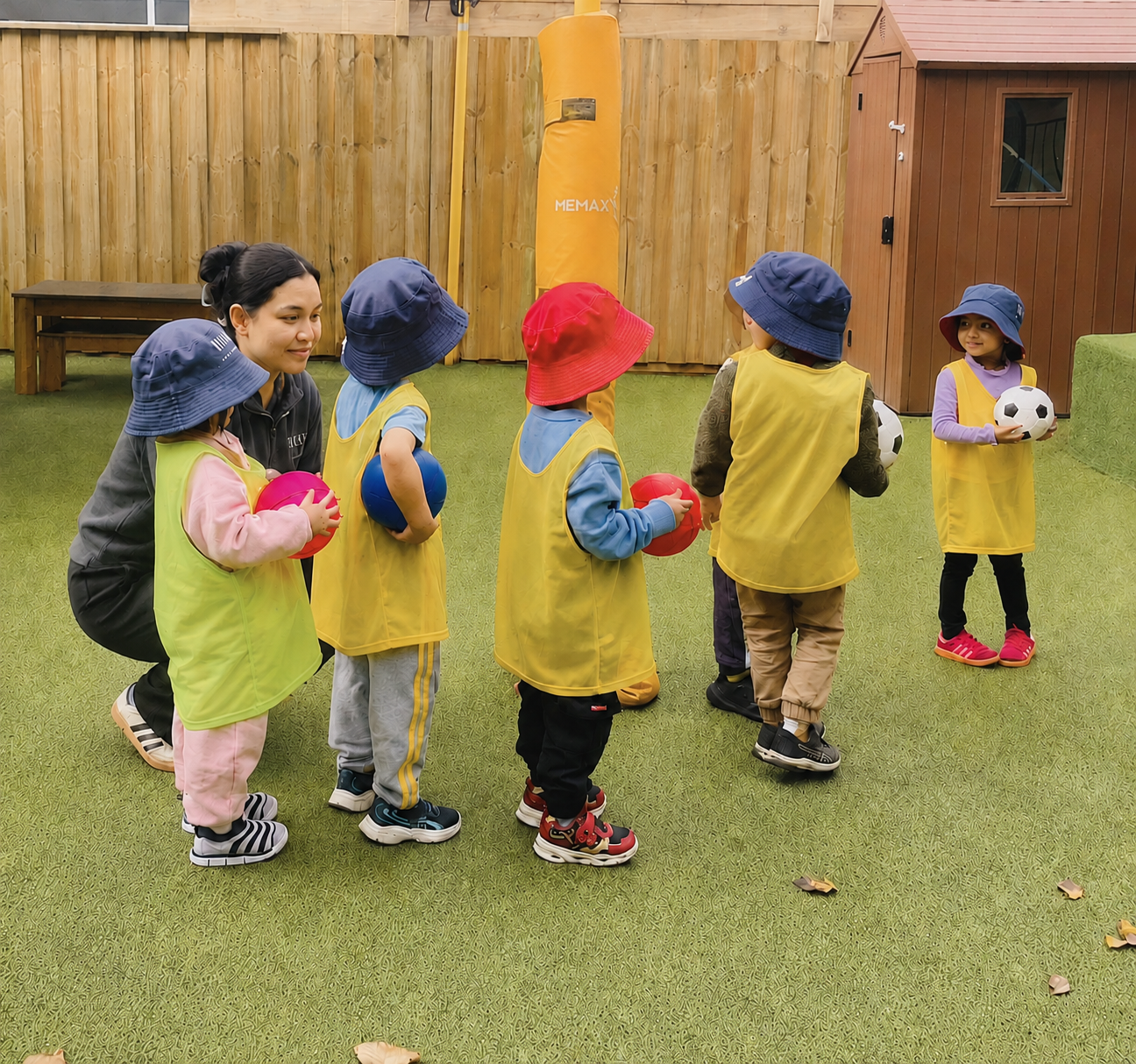 Child smiling during outdoor ball play at Kelvin Kindergarten St Ives
