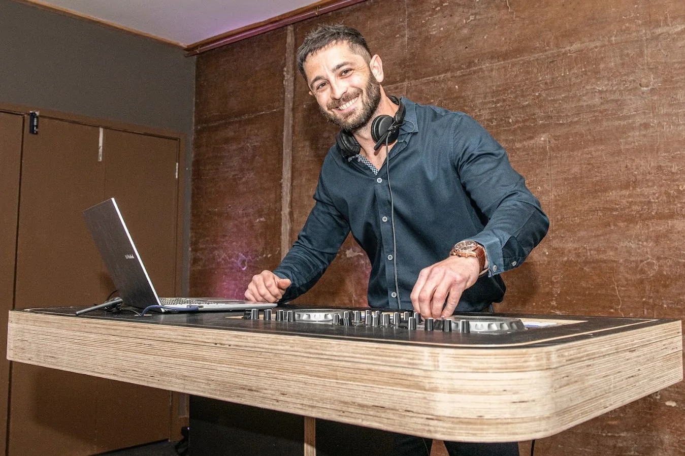 Alistair Rutherford DJing behind a wooden booth at an Elmore Court wedding