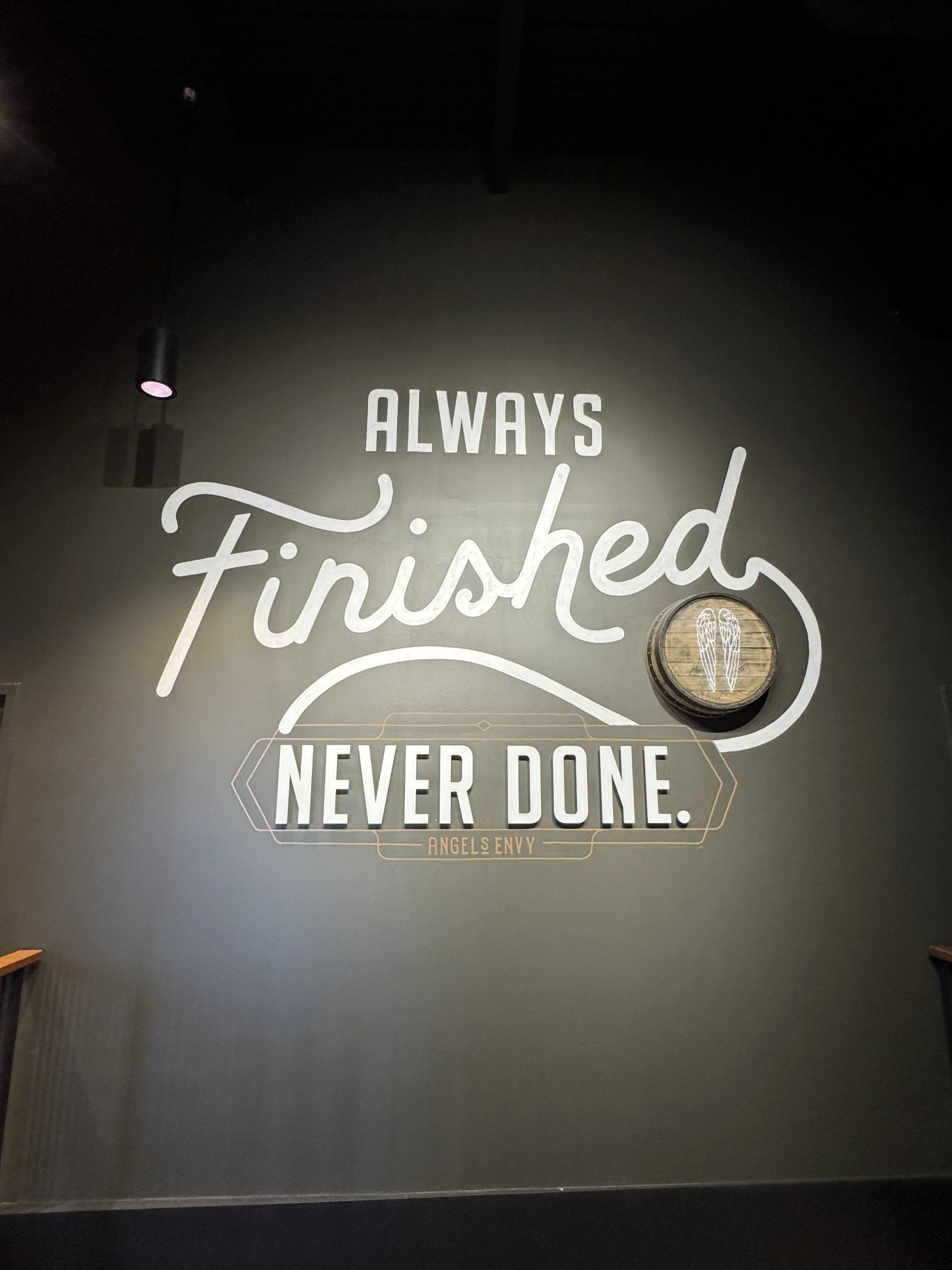A sign on the way out of the distillery that reads Always Finished, Never Done.