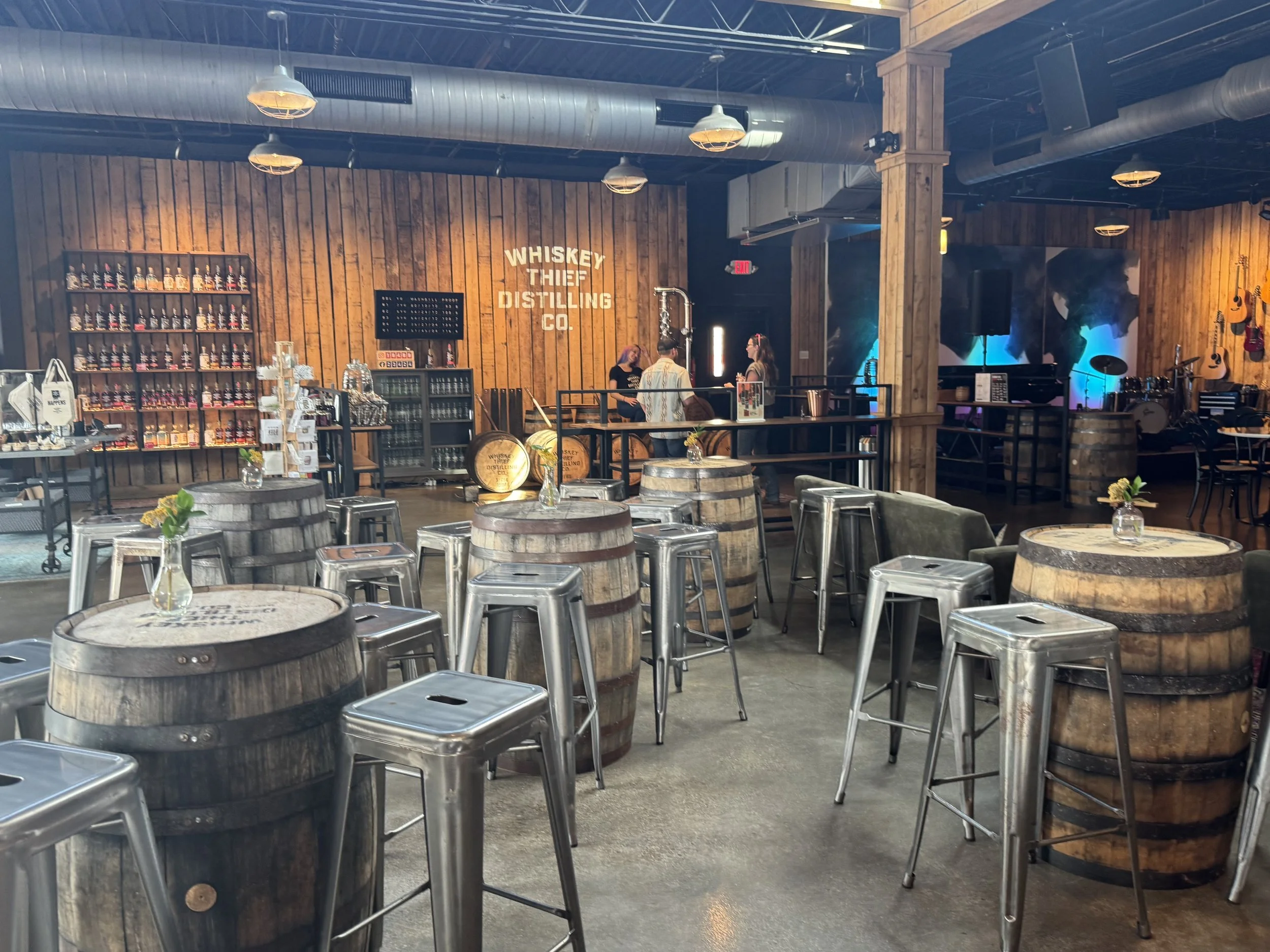 Tasting Room for a whiskey and gin distillery, featuring barrels, a live music stage, and a gift shop