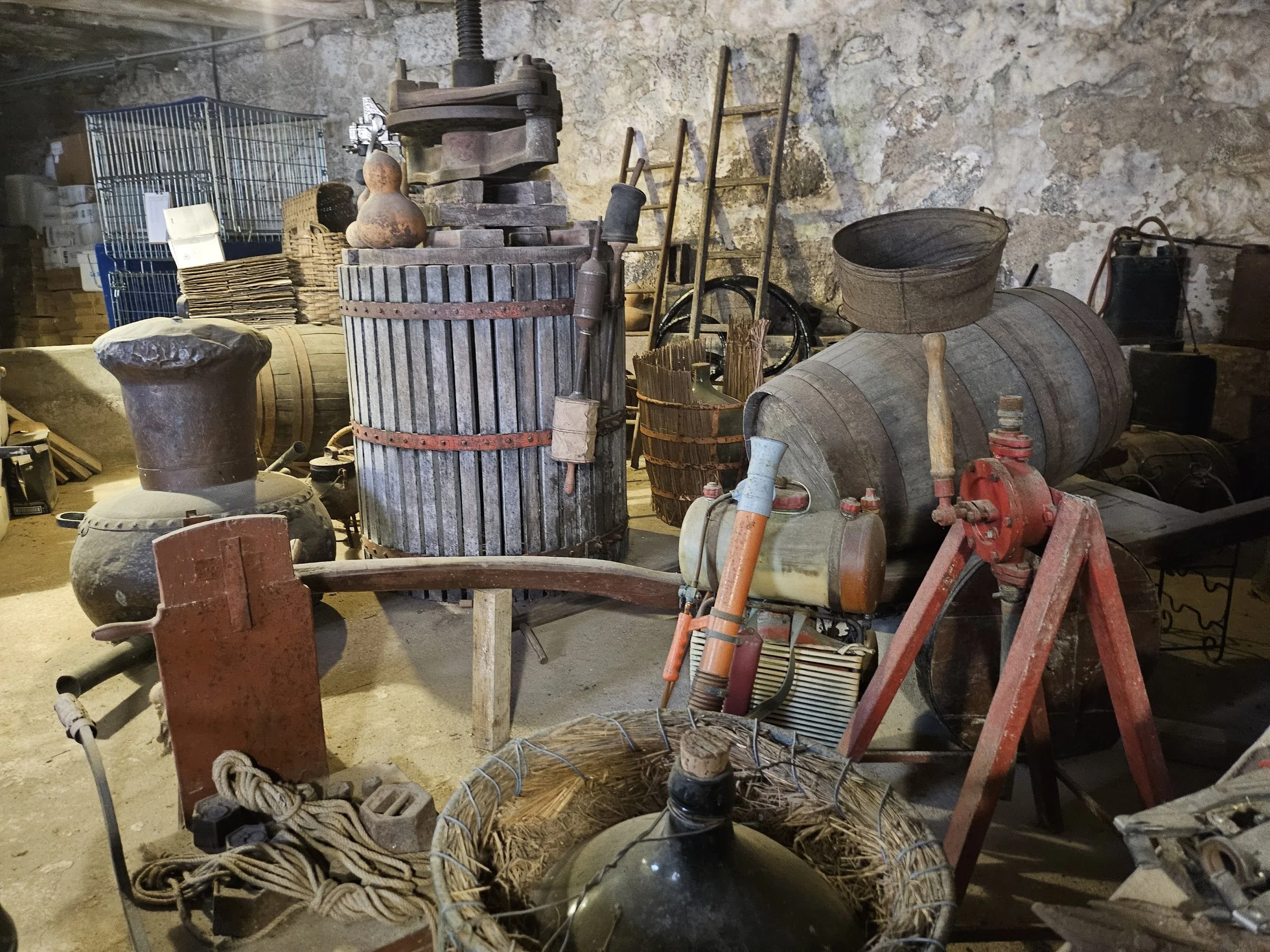 Old winery artifacts including a grape press and copper still