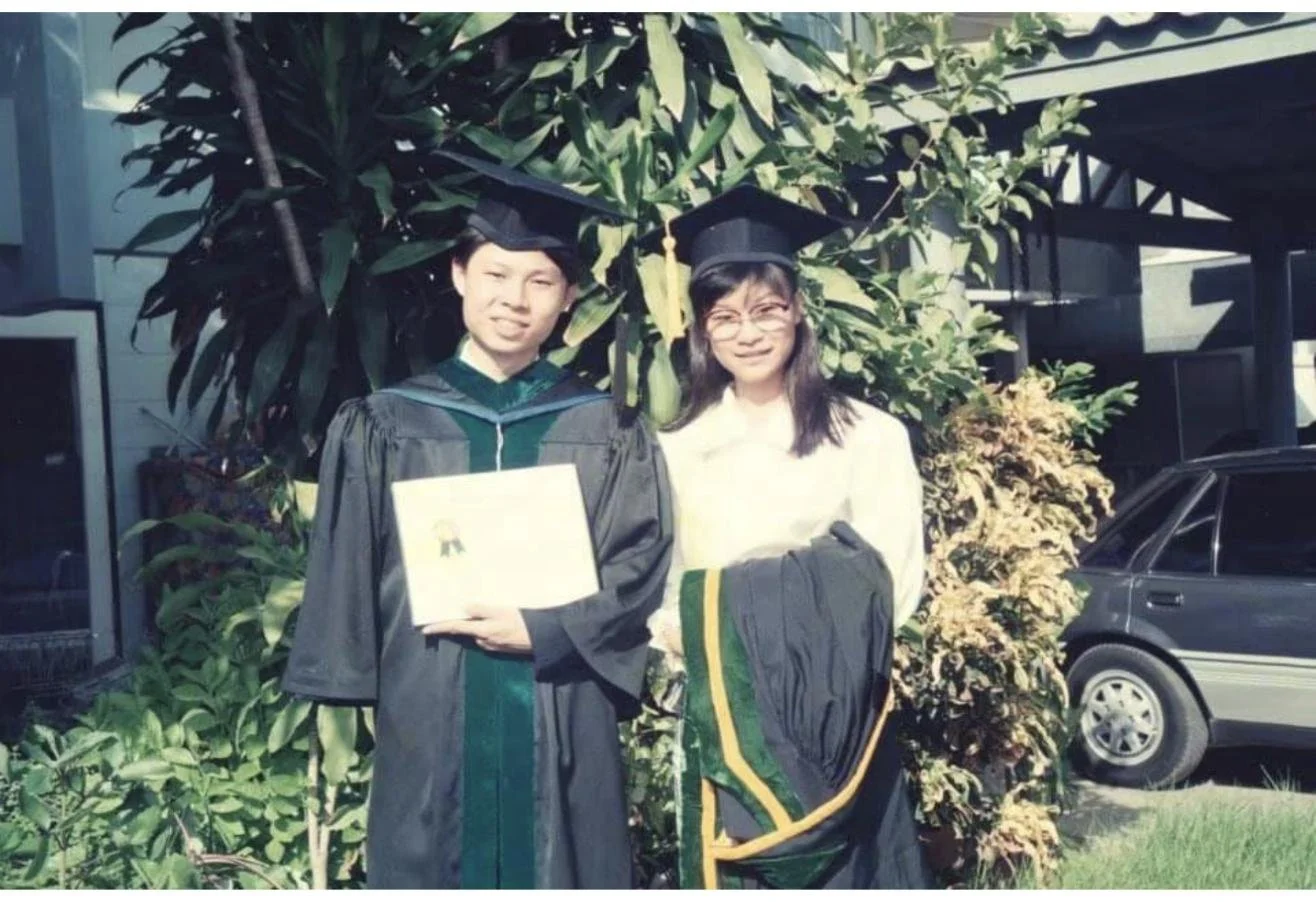 Dr. Rushapol Sdawat in a black and green graduation gown and mortarboard, holding his degree certificate