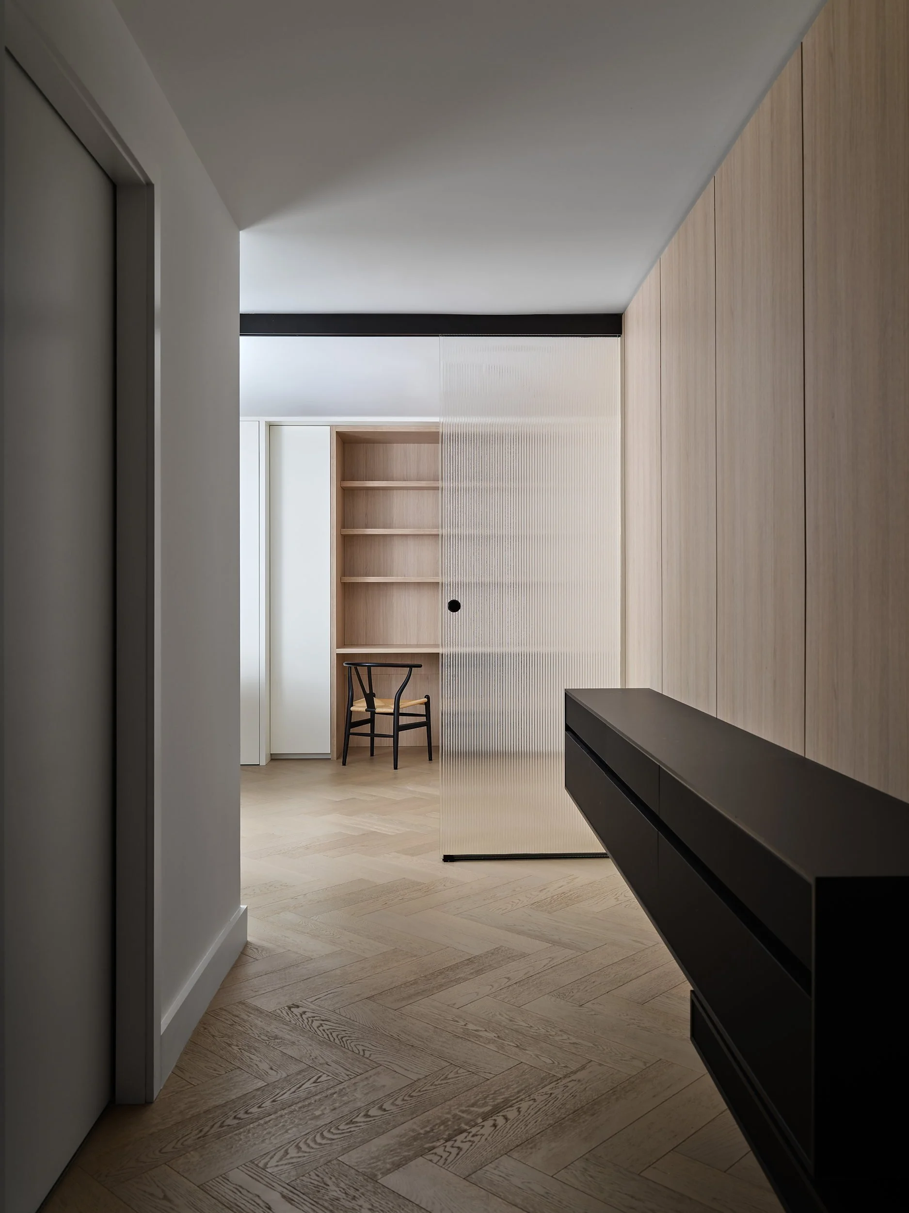 White-oak-panelled den with a floating black console at Shangri-La 37.