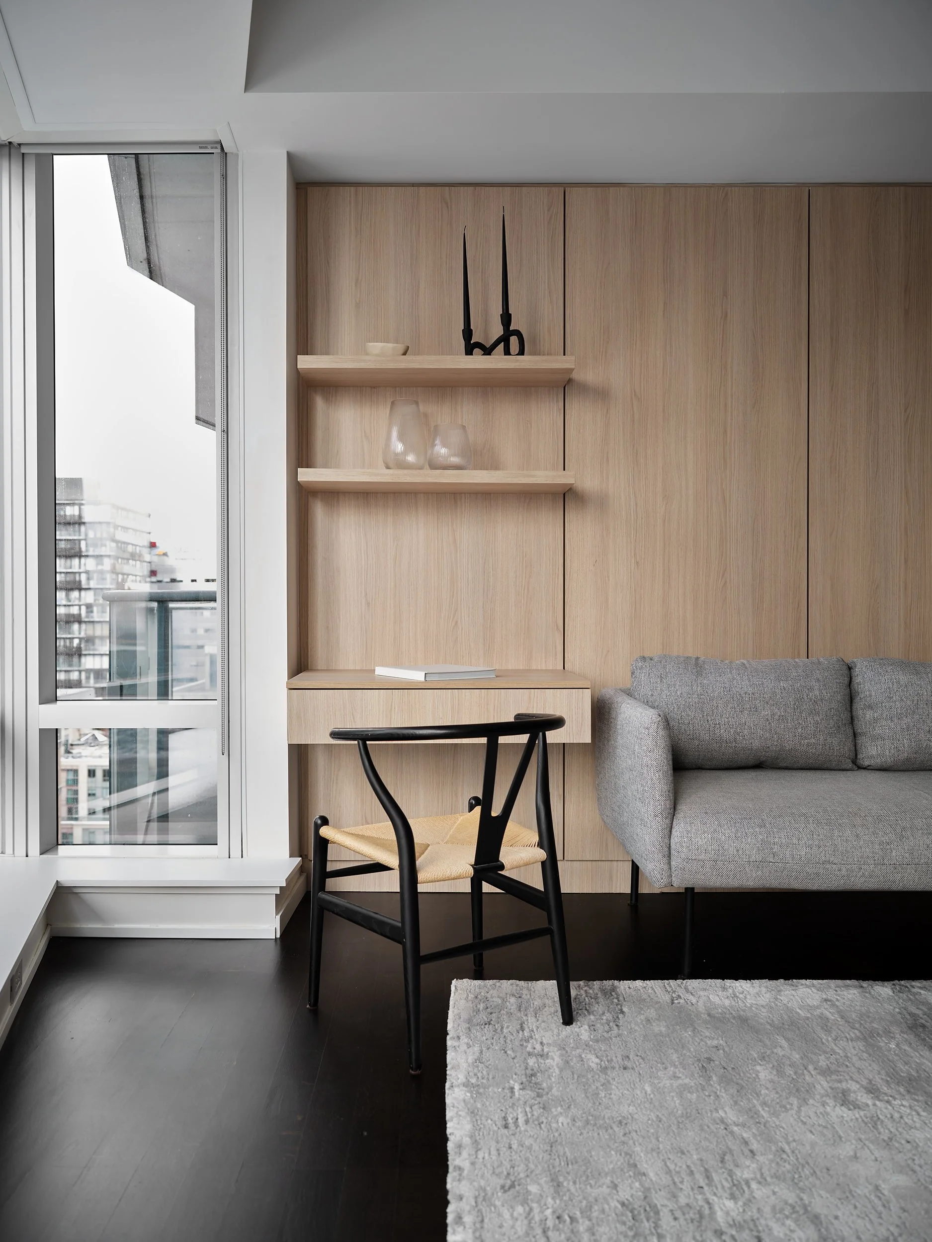 Built-in white oak desk and shelving beside the living room window.