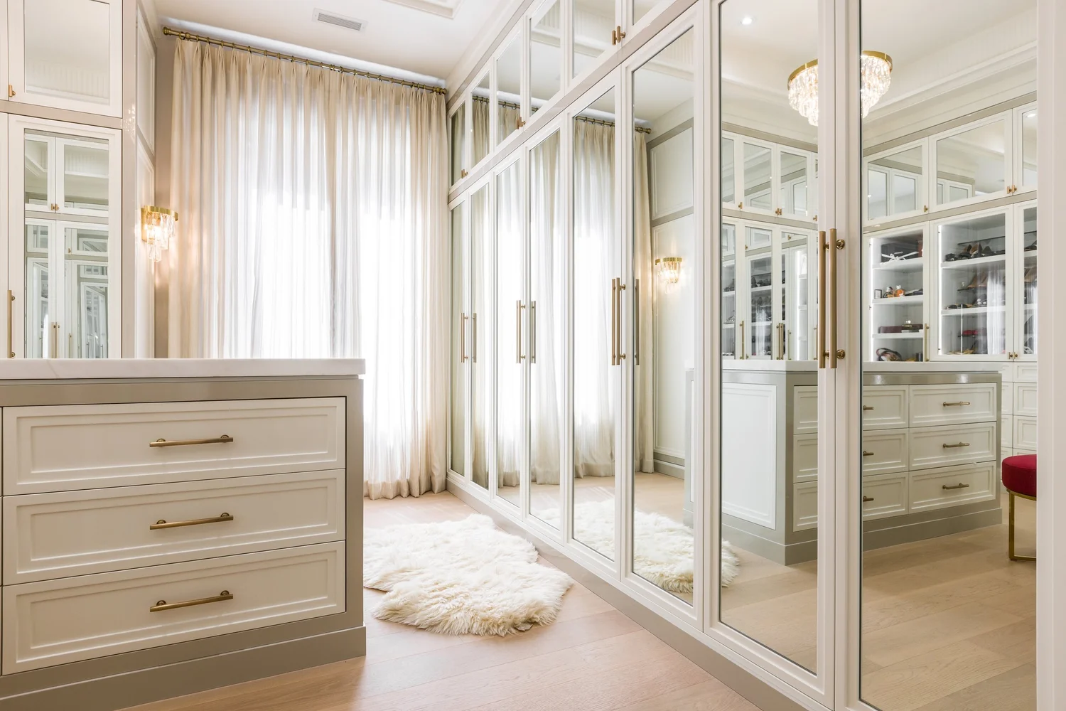 Dressing room with a central island and mirrored wardrobe doors.