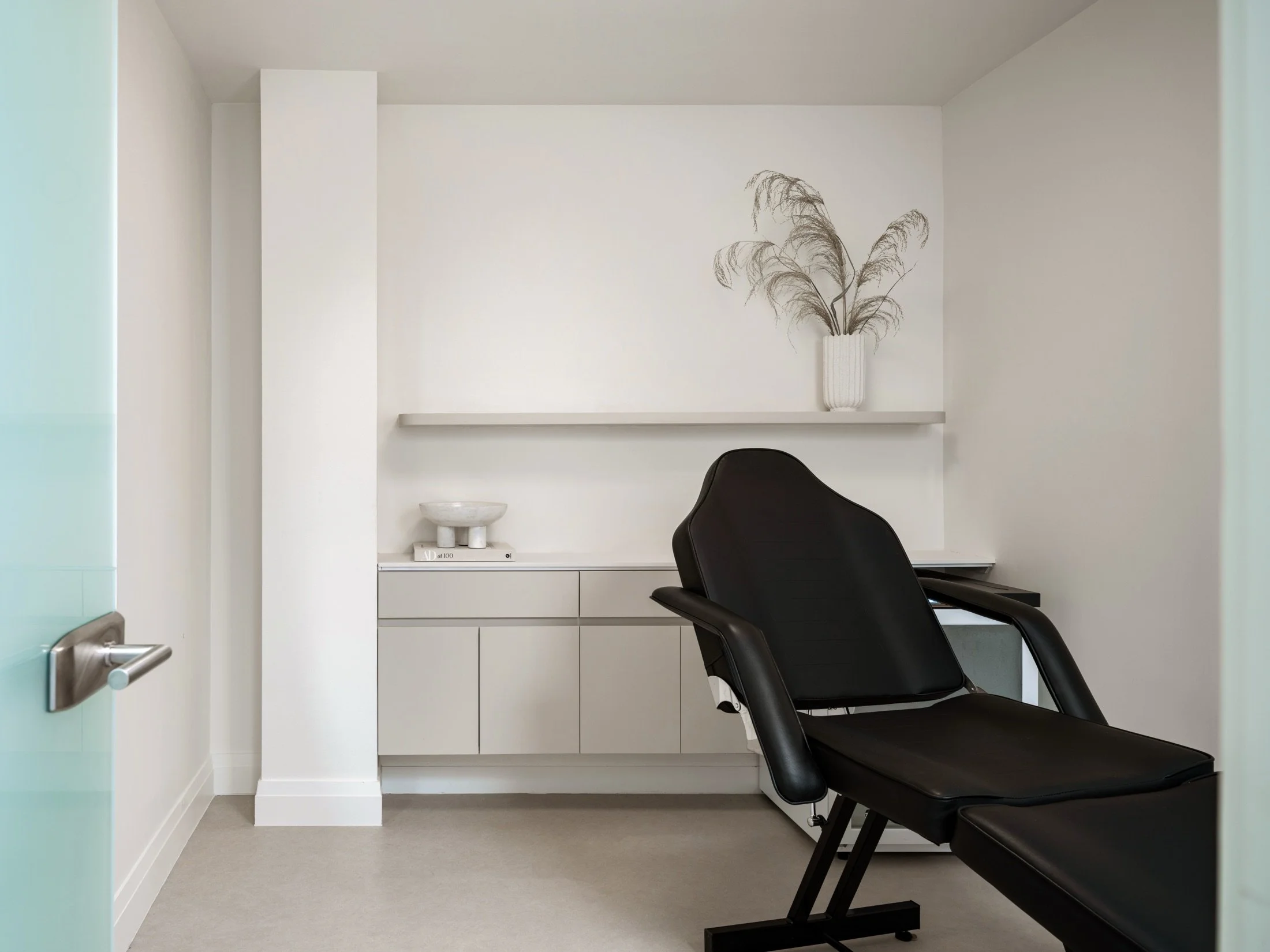 Patient room at Trillium Yorkville with integrated low cabinetry and a floating display shelf.