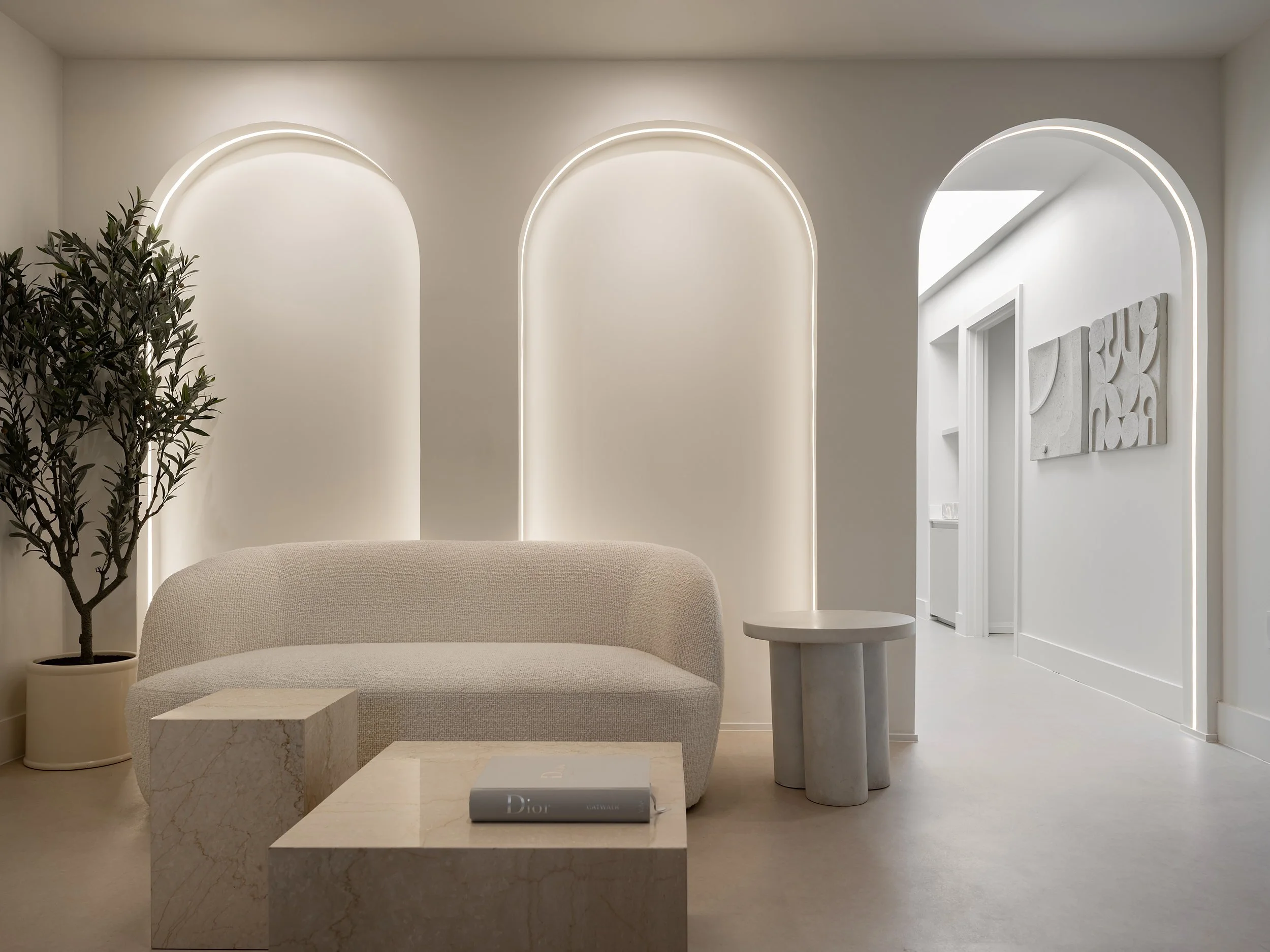 Lounge seating beneath twin backlit arches with corridor beyond.