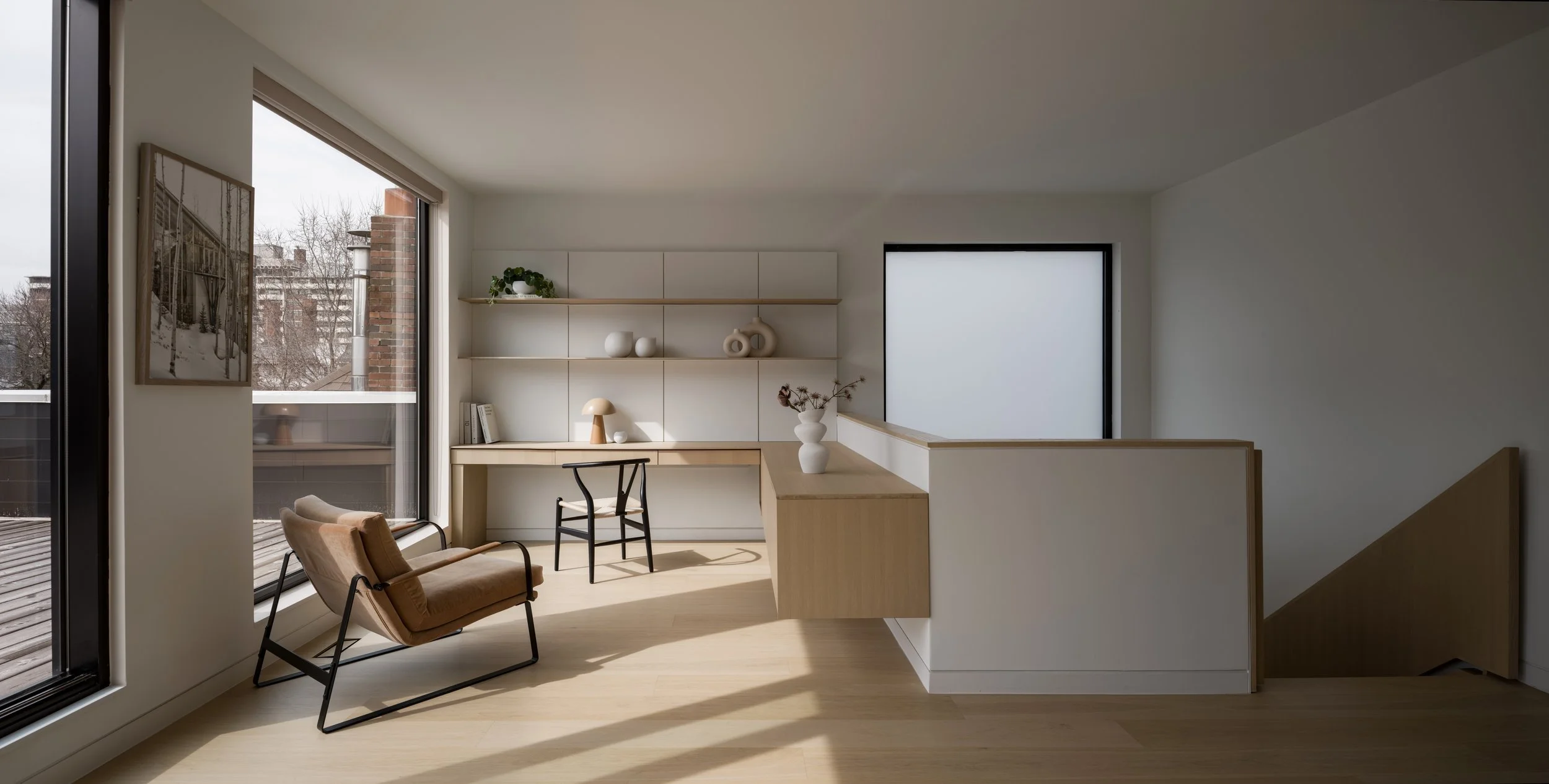 Third-floor office with an integrated desk, two windows, and the adjacent staircase.