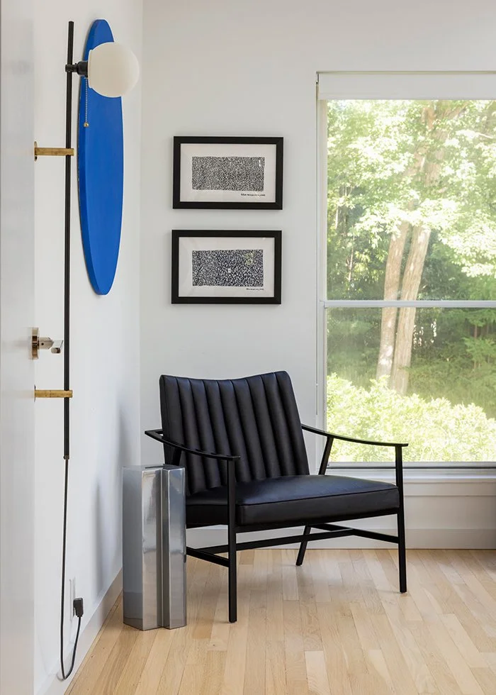 Modern reading nook, black accent chair, wall sconce