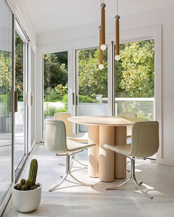 Modern dining nook, round pedestal table, floor to ceiling windows