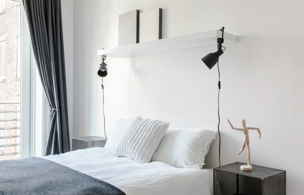 Chelsea Duplex, metal nightstands with gray drapes