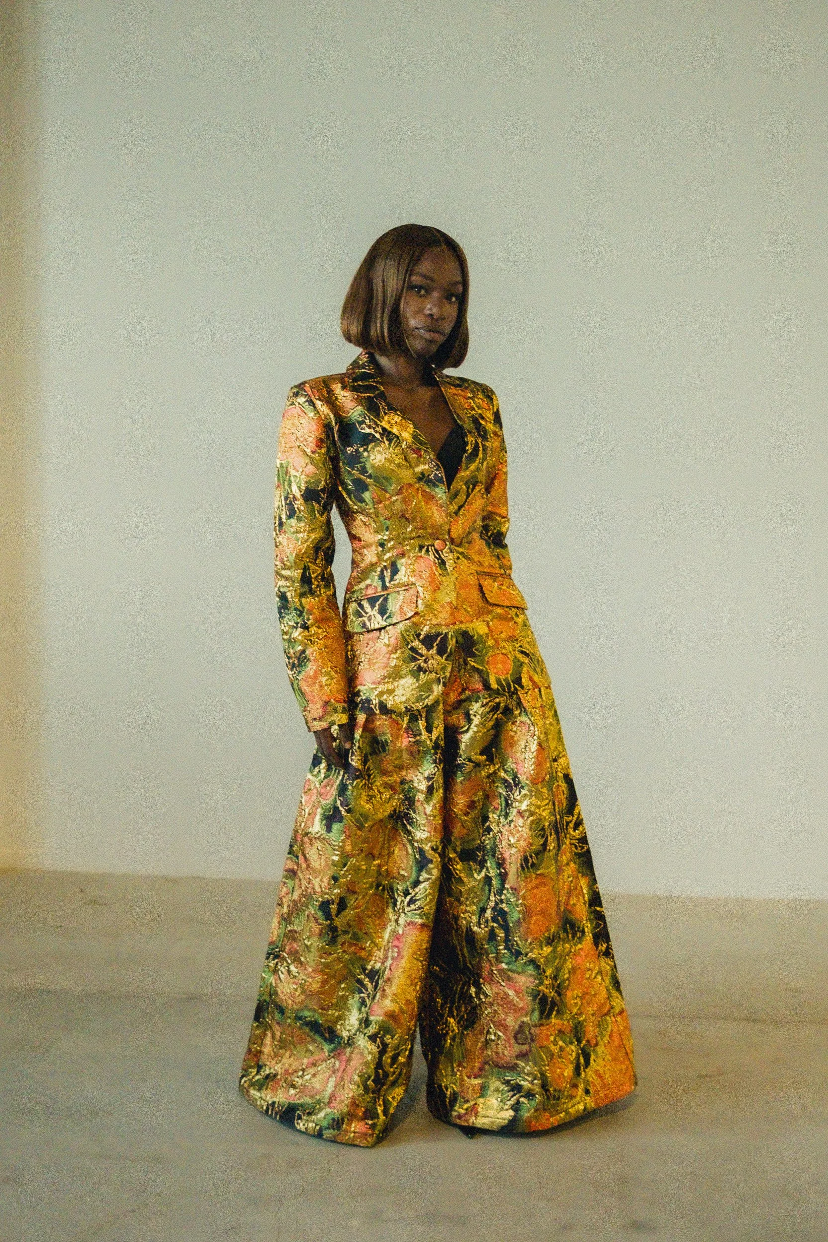 A full length portrait of Patience in her patterned outfit