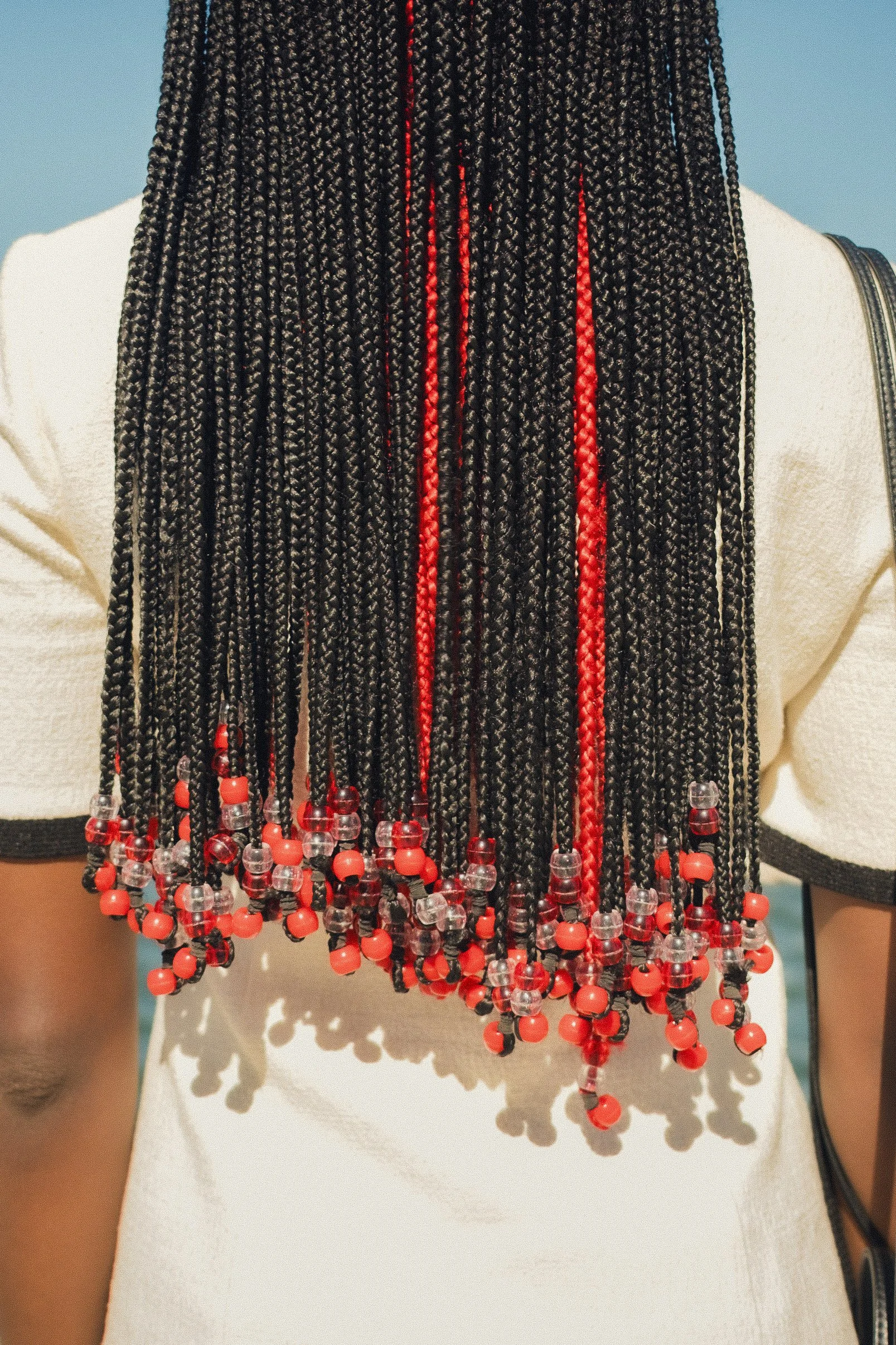 A close view of DION’s braids and red beads