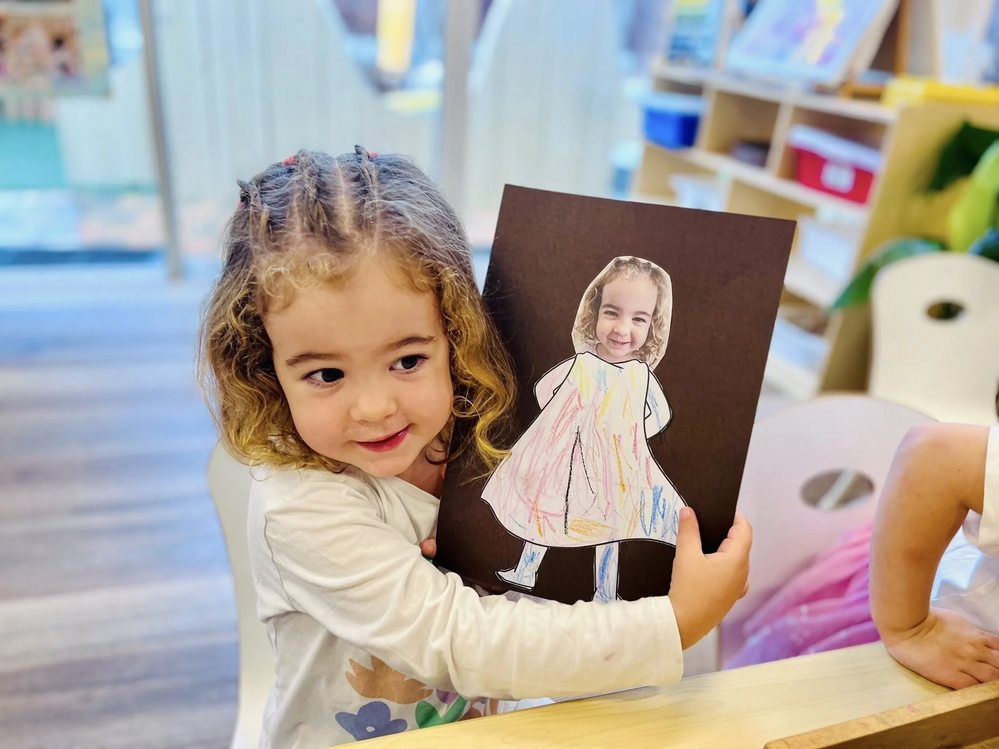 A child proudly sharing creative work at Balgowlah Early Learning