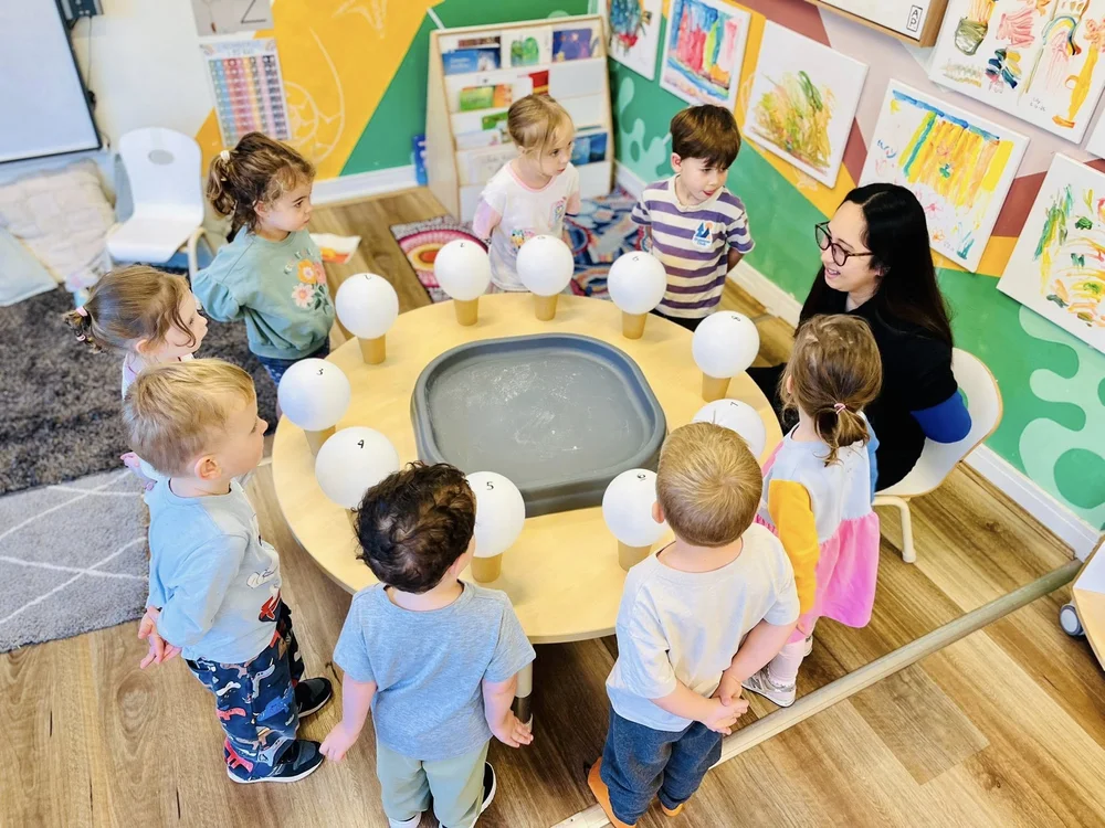 A BEL educator supporting children at an activity table