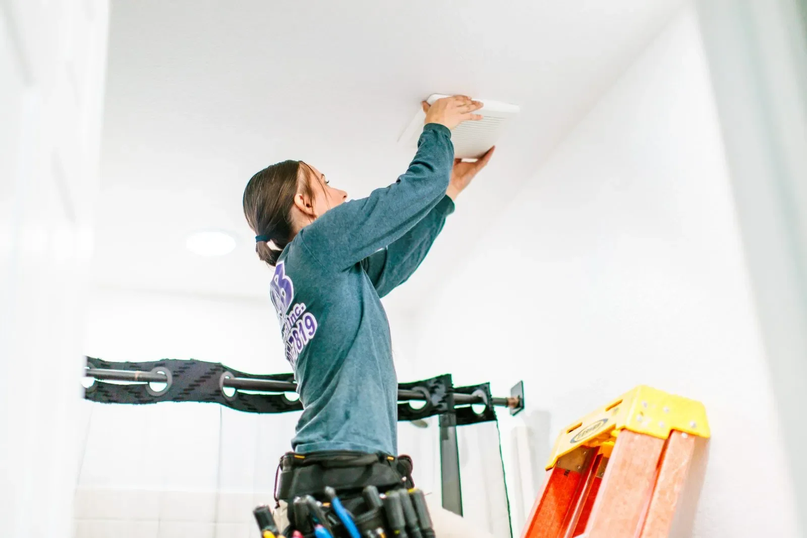 Electrician installing exhaust fan bright interior — RSB Electrical, Mesa AZ