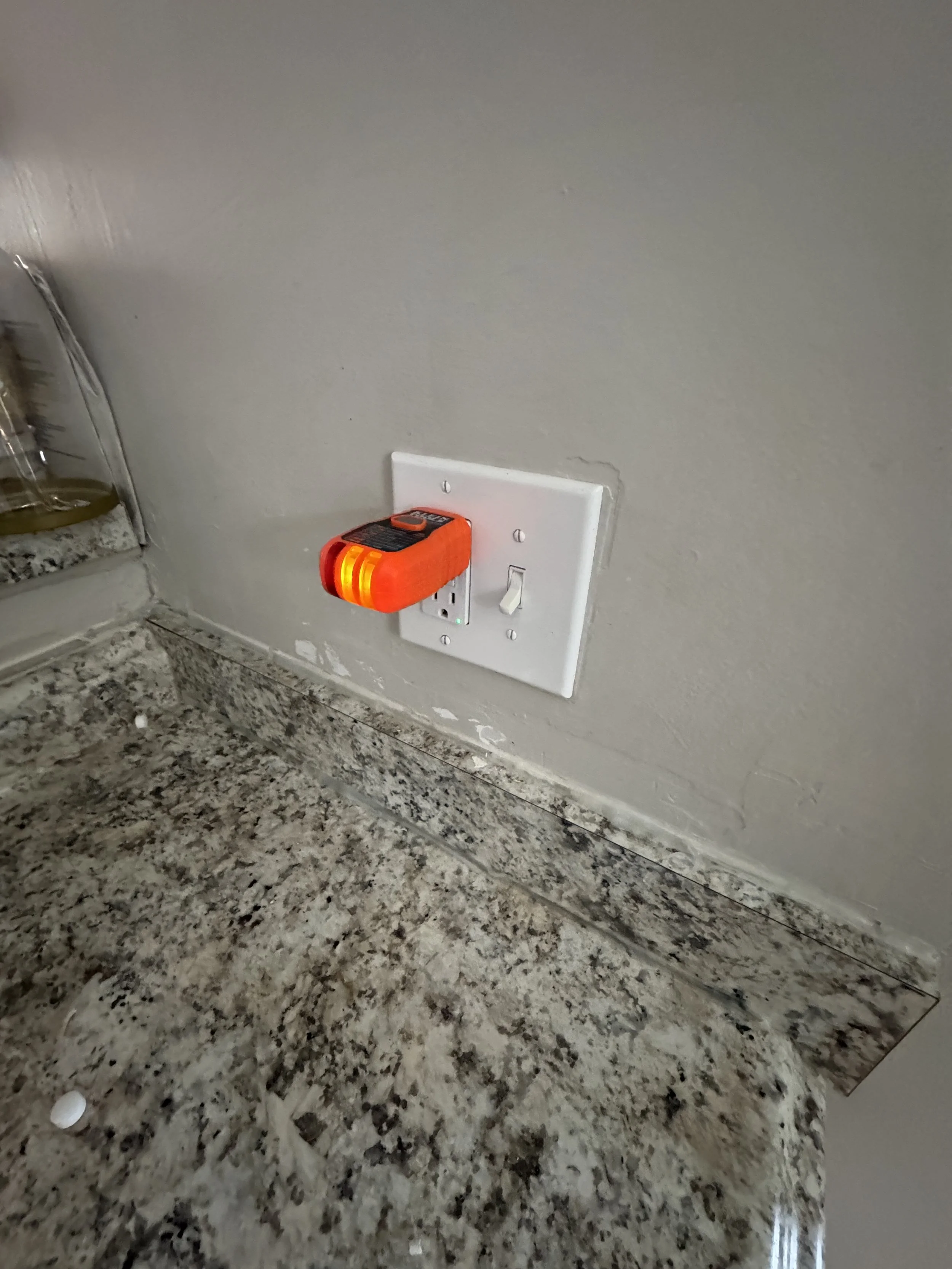 Receptacle at a kitchen counter with a plug-in tester showing its result, Suffolk, VA