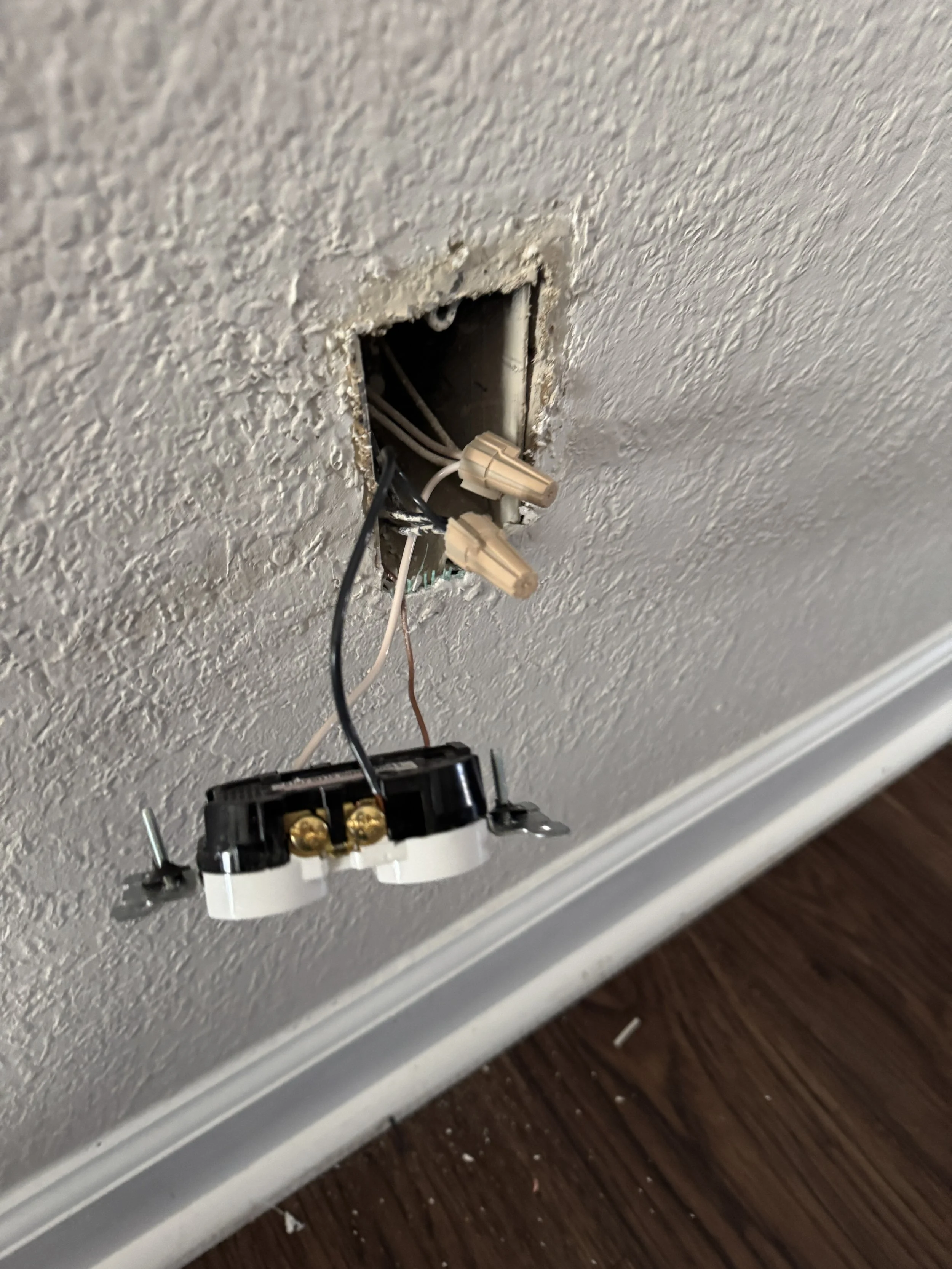 Old receptacle taken off the wall with its conductors left in the opening