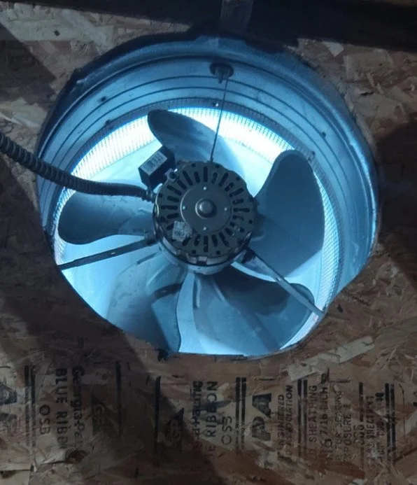 Gable fan among the rafters and sheathing of an attic in an older Suffolk, VA house