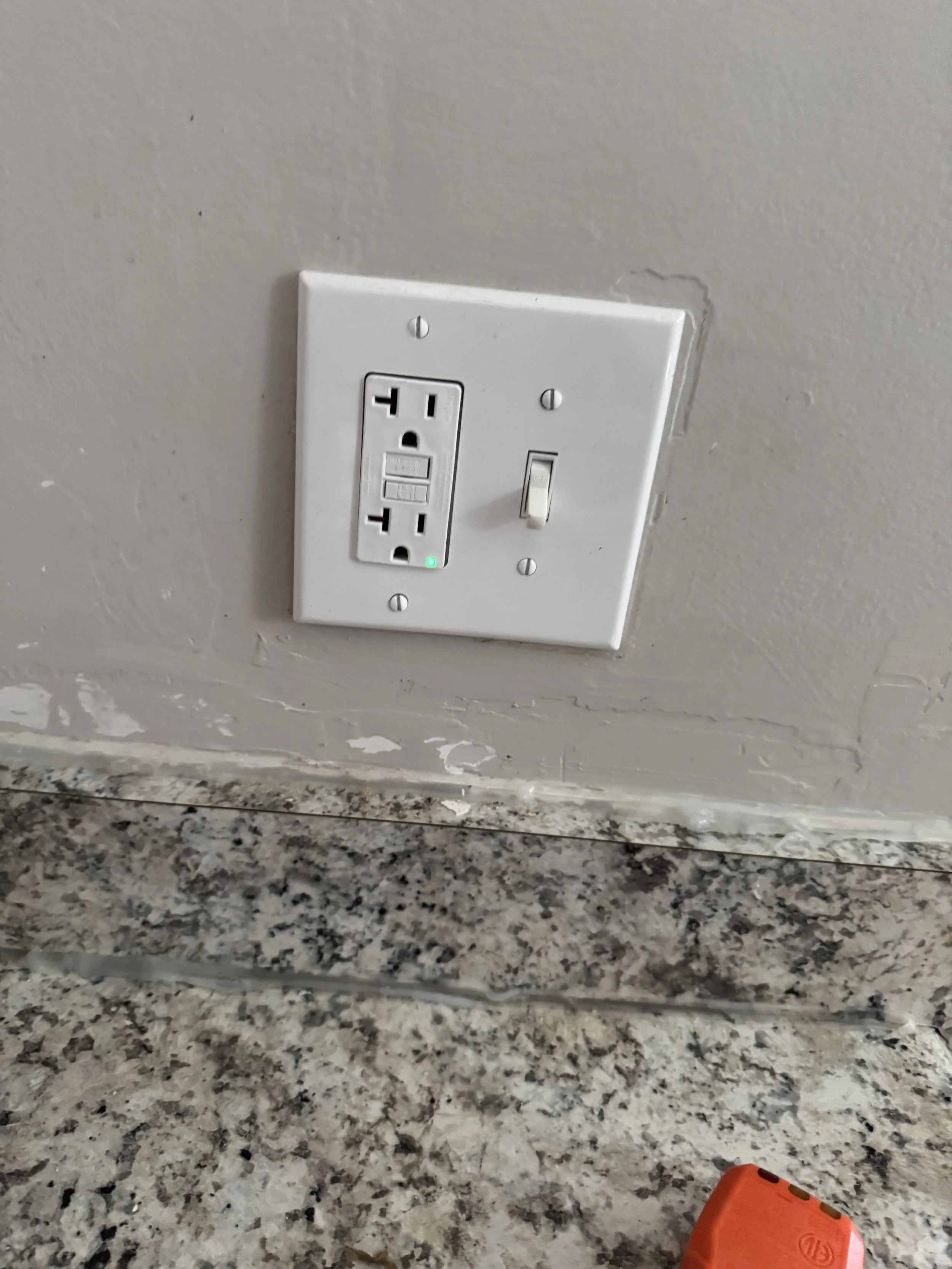 GFCI receptacle with its TEST and RESET buttons beside a switch in a Suffolk, VA home