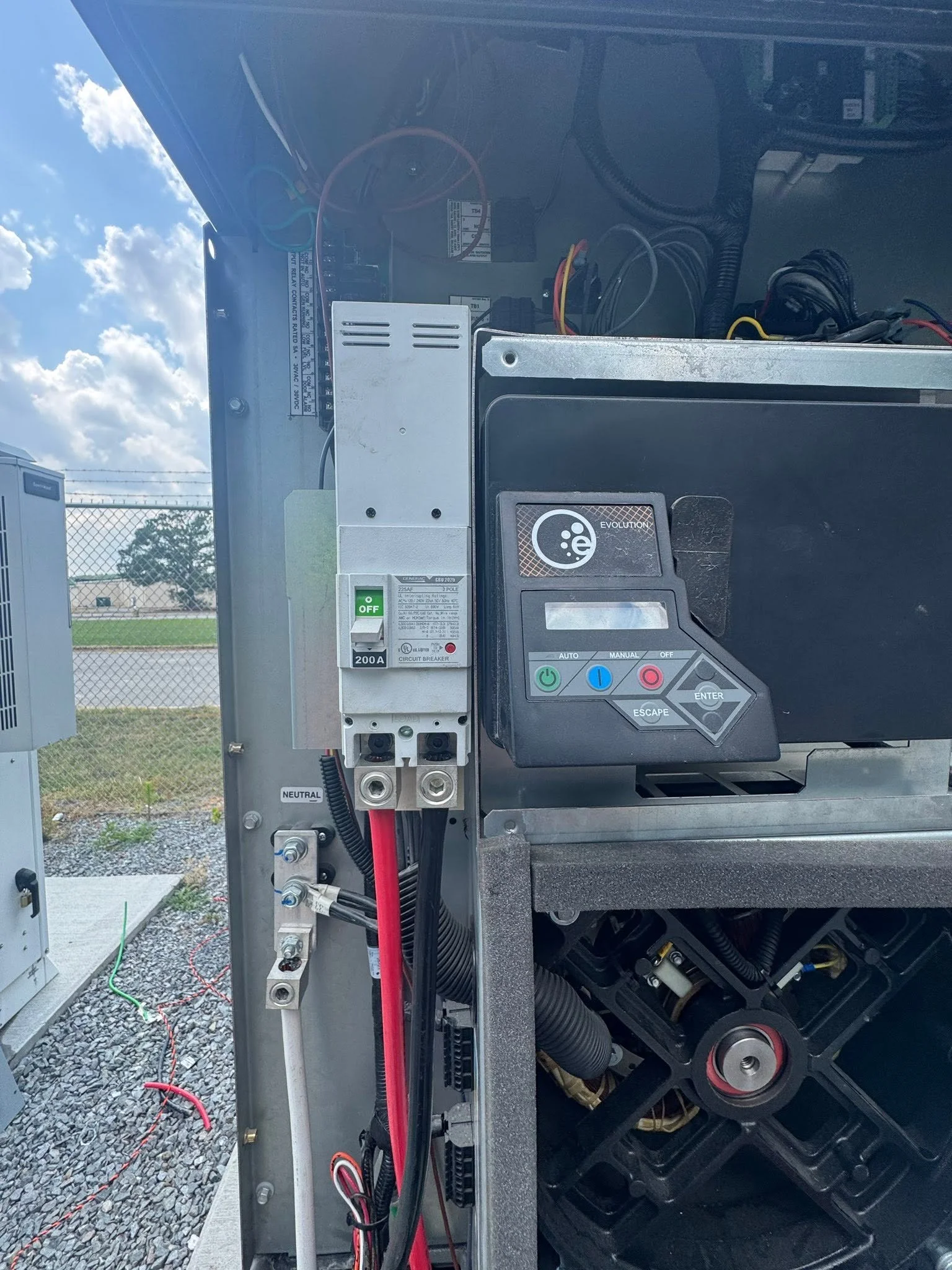 Control panel and main breaker inside an open generator enclosure