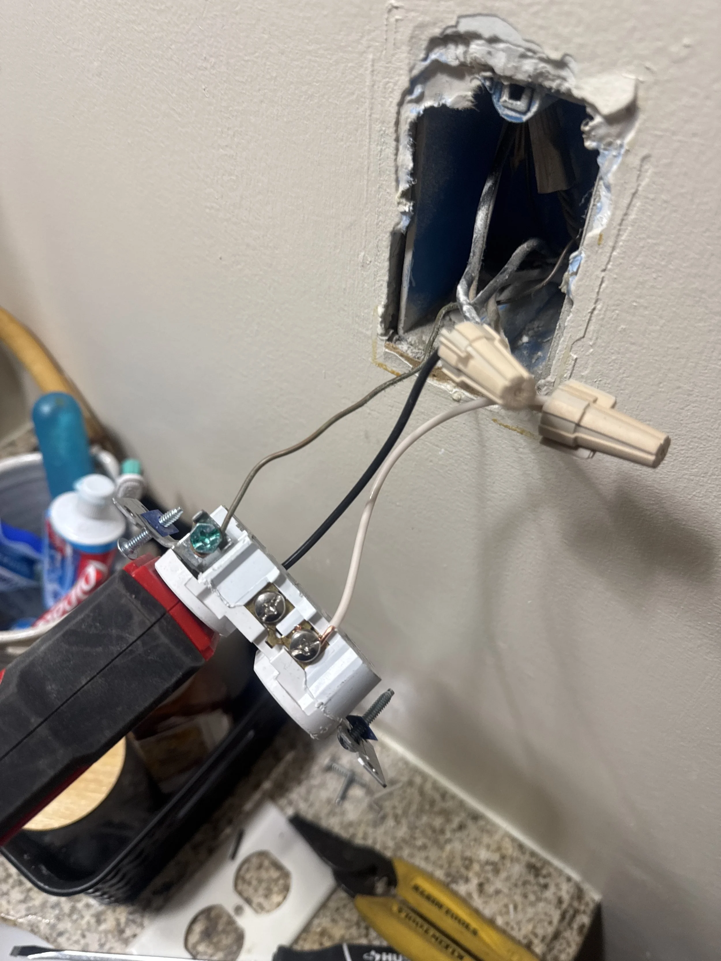 Receptacle and its conductors pulled out through a hole cut in a wall