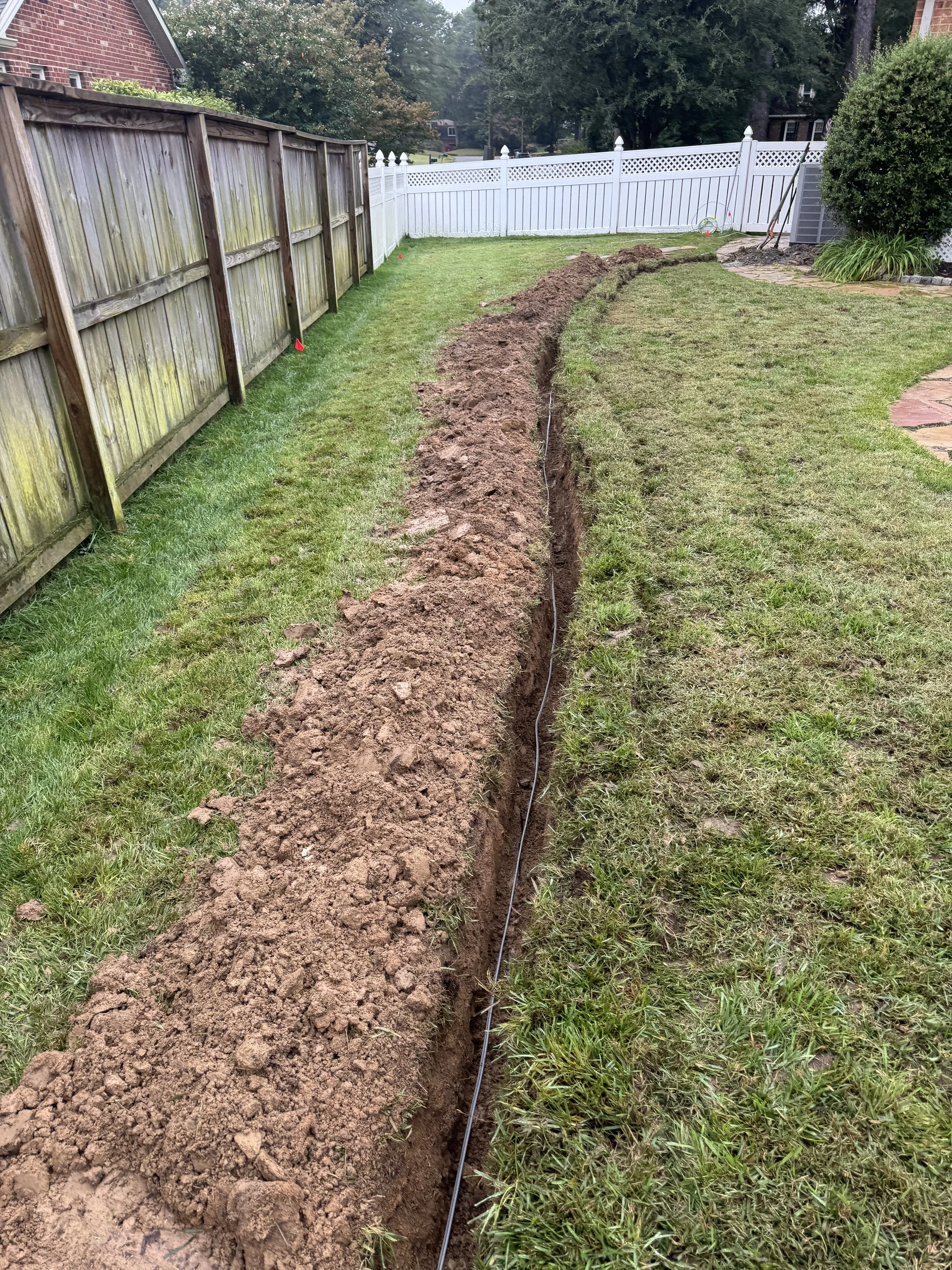 Long feeder trench running the length of a back lawn in Suffolk, VA