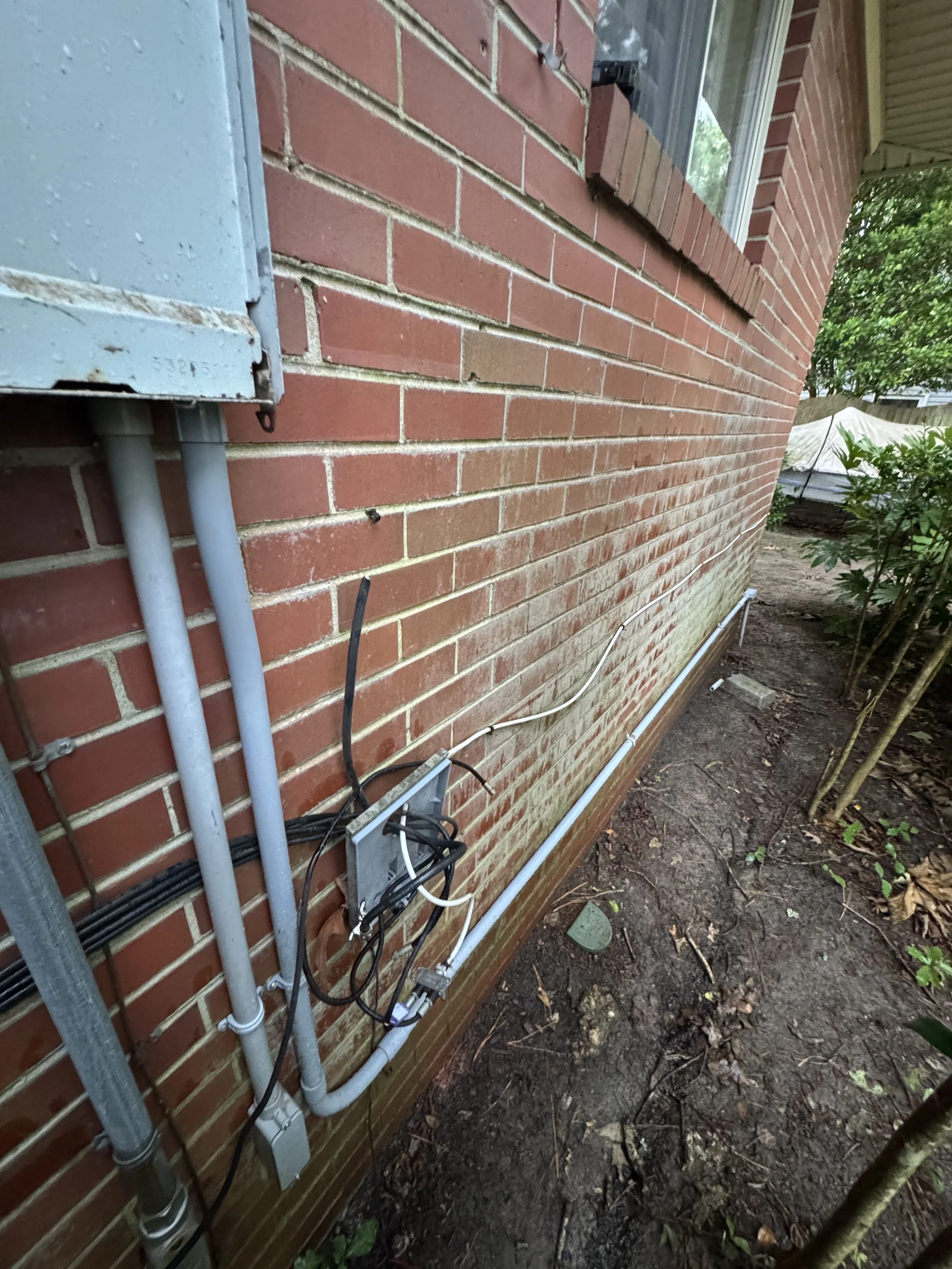Existing feed leaving a Chesapeake, VA house wall on its way to an outbuilding