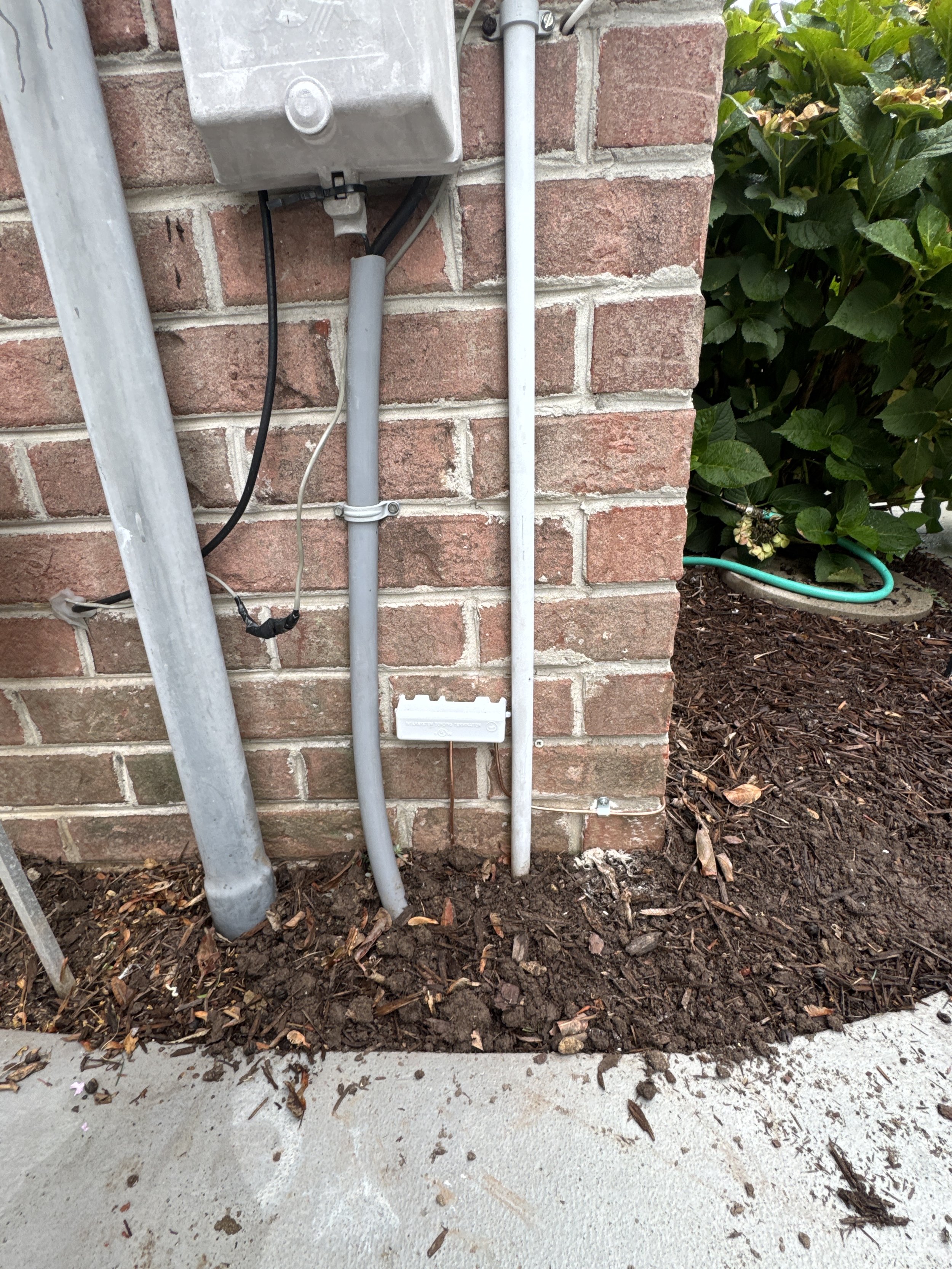 Charging circuit conduit routed down the wall and sealed where it enters the ground