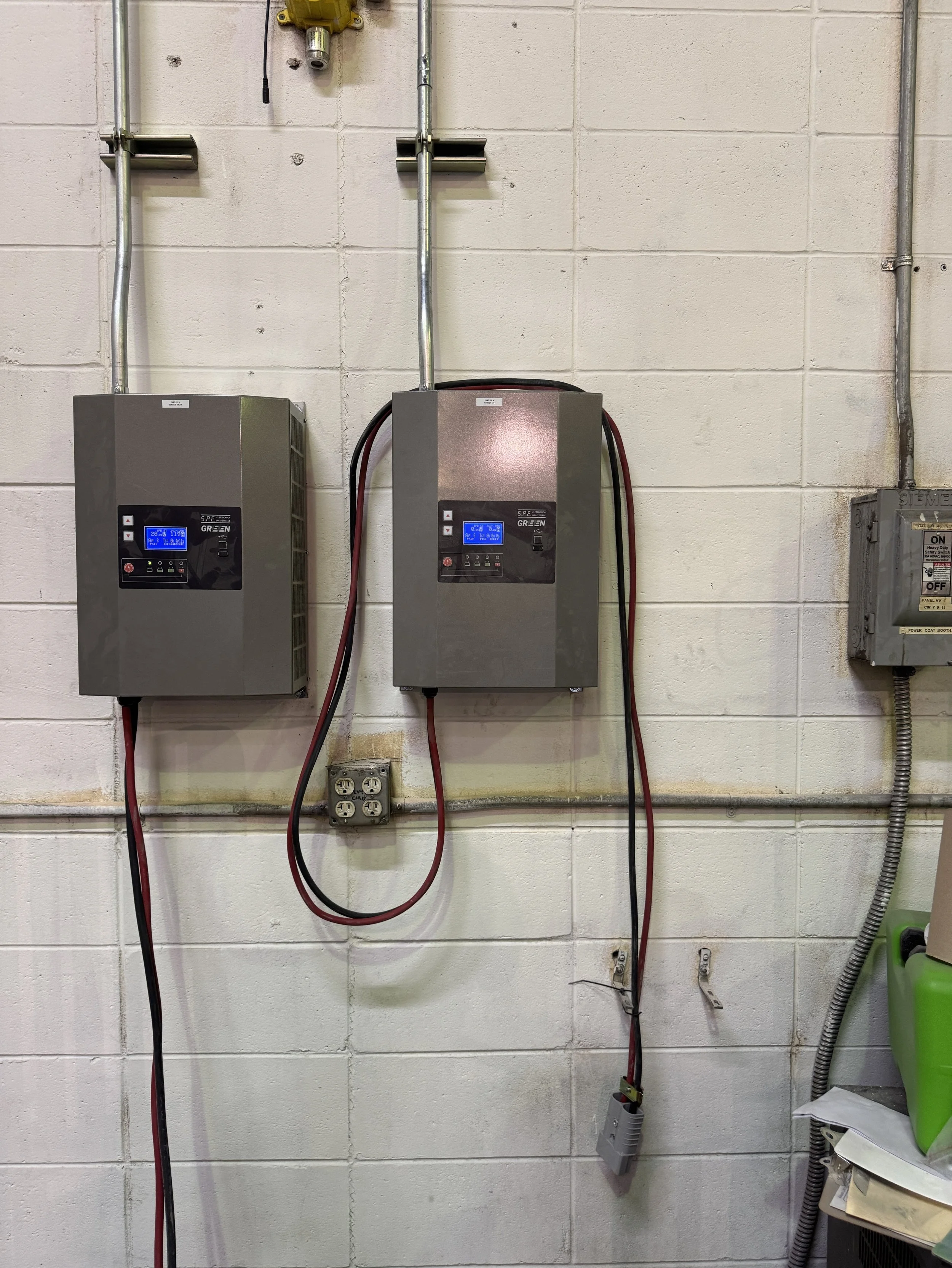 Wall-mounted commercial electrical equipment and conduit on a block wall