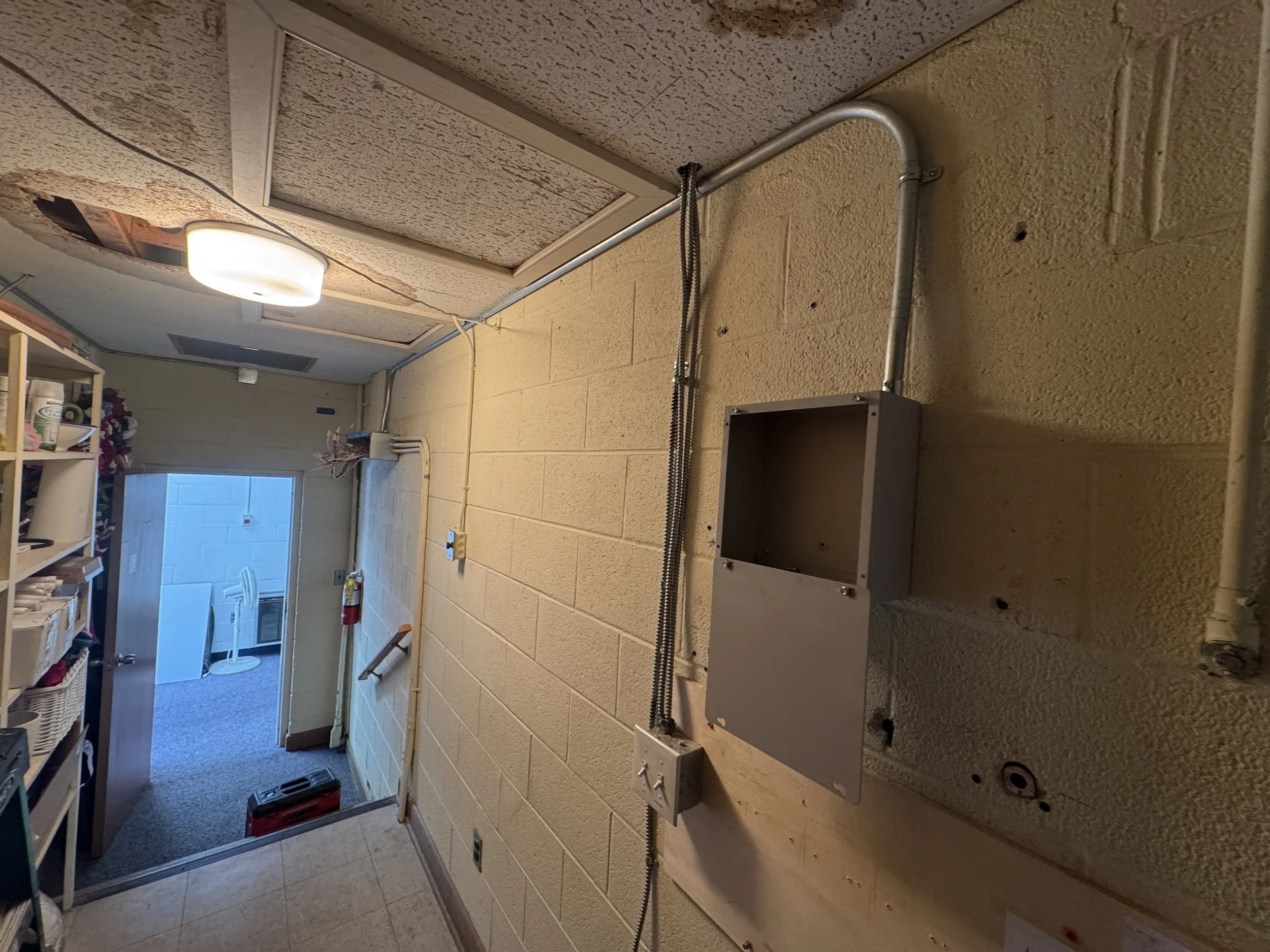 Back-of-house corridor of a commercial building during an electrical renovation