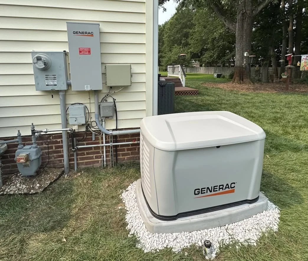 Standby generator on its pad with the transfer switch on the house wall, Chesapeake, VA