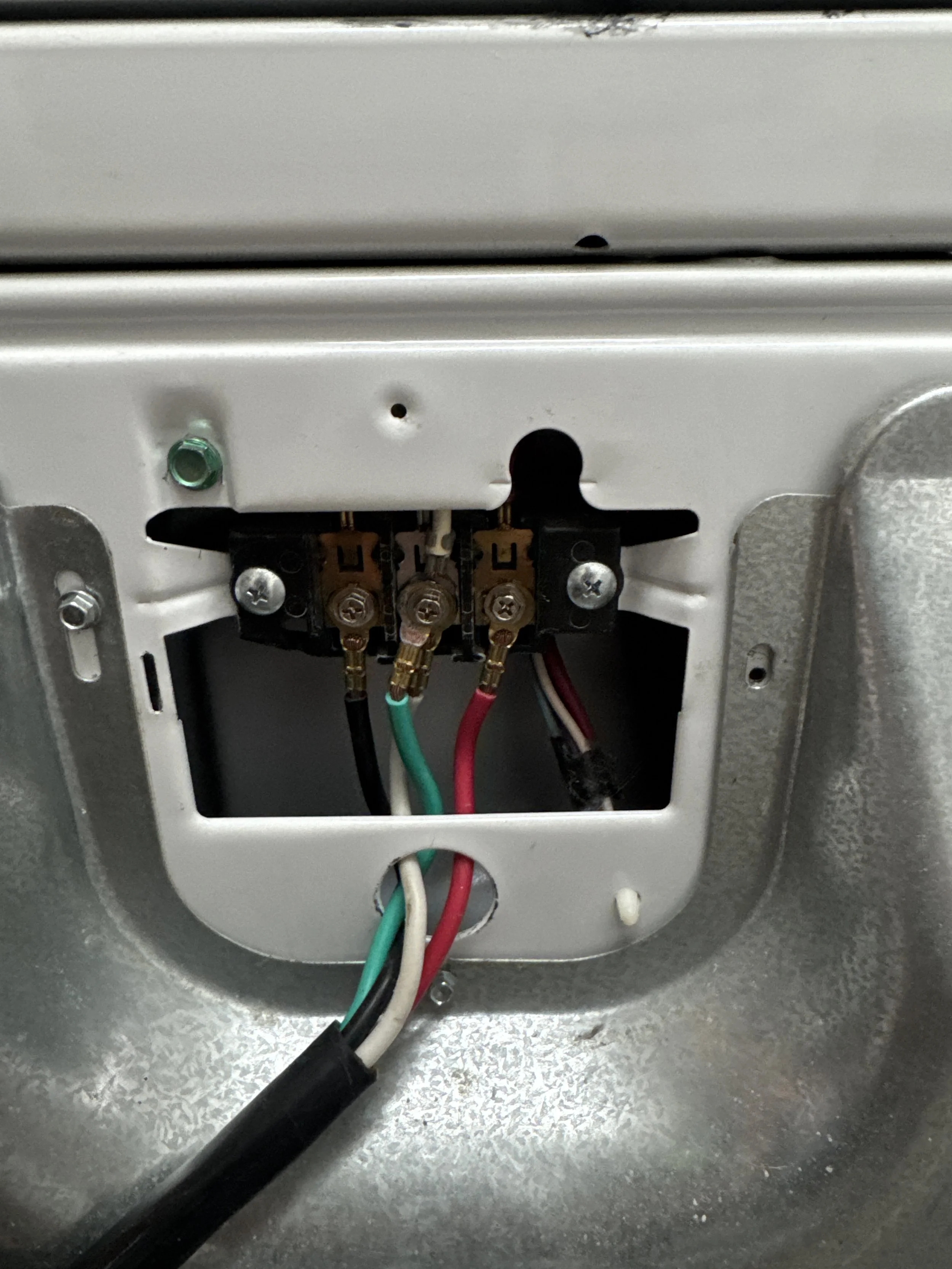 Appliance terminal block with the cord leads landed behind the back panel