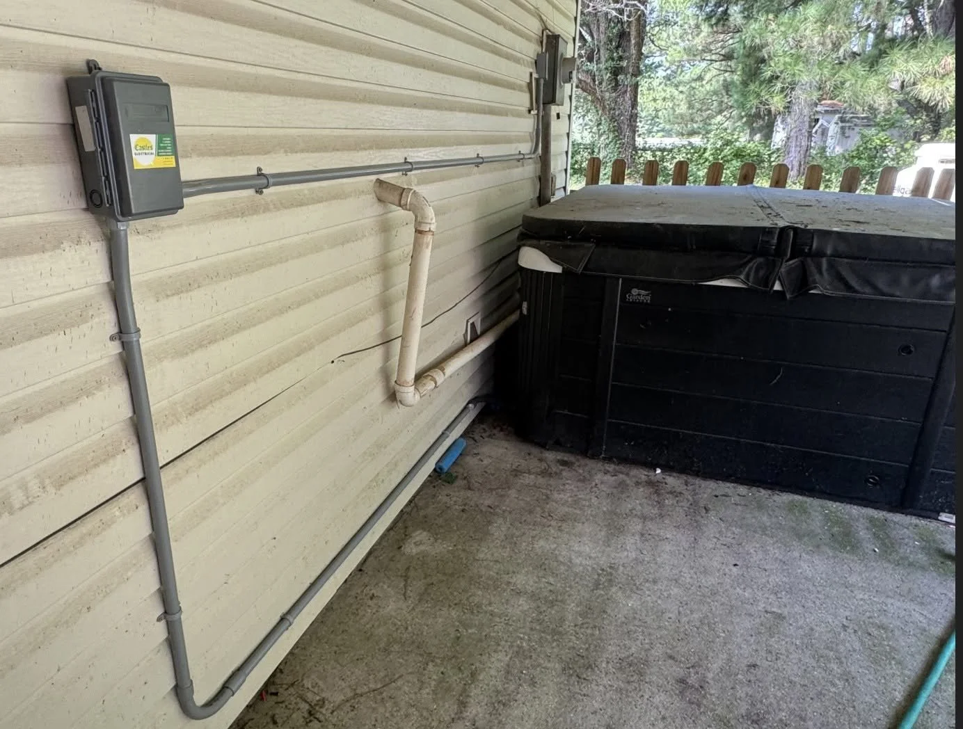 Hot tub beside a Chesapeake, VA home with its disconnect mounted on the house wall