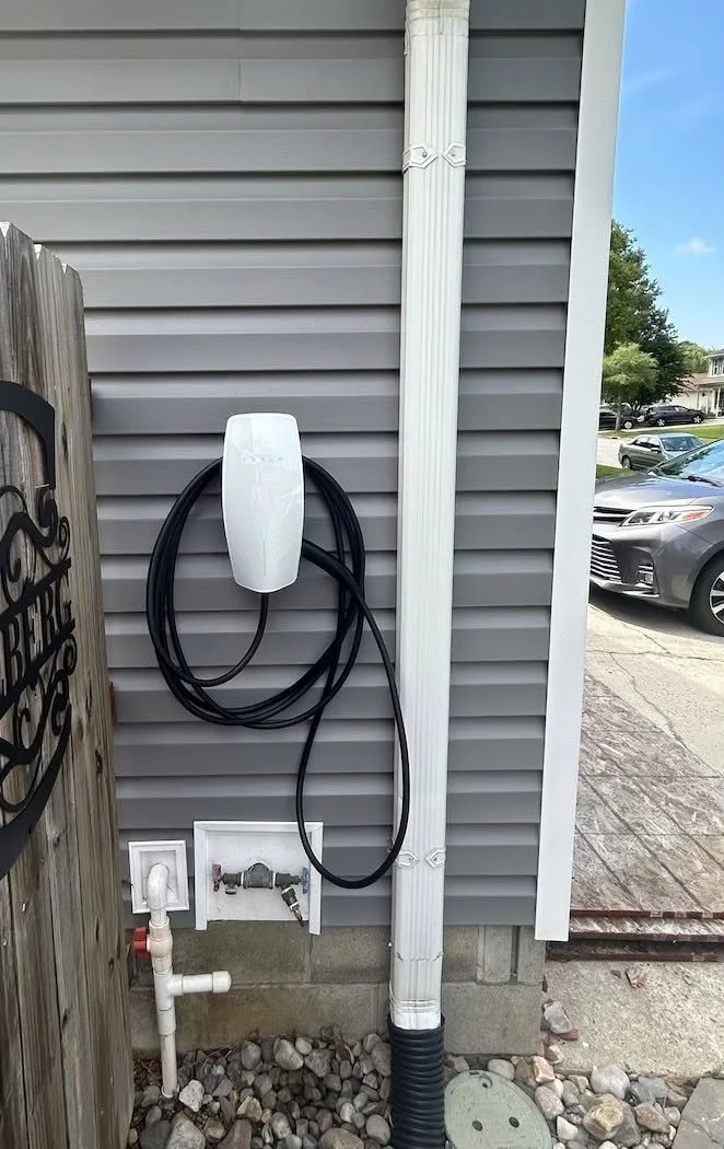 Level 2 charger left fully set up beside the driveway of a Suffolk, VA home