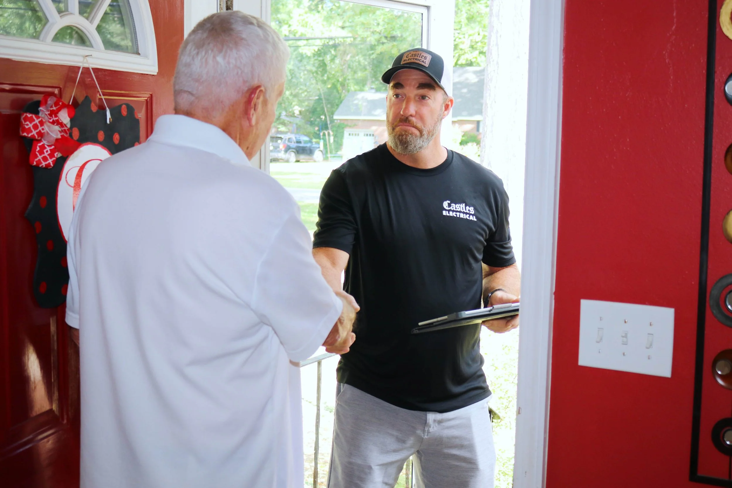 Castles Electrical electrician talking a customer through the visit at the door