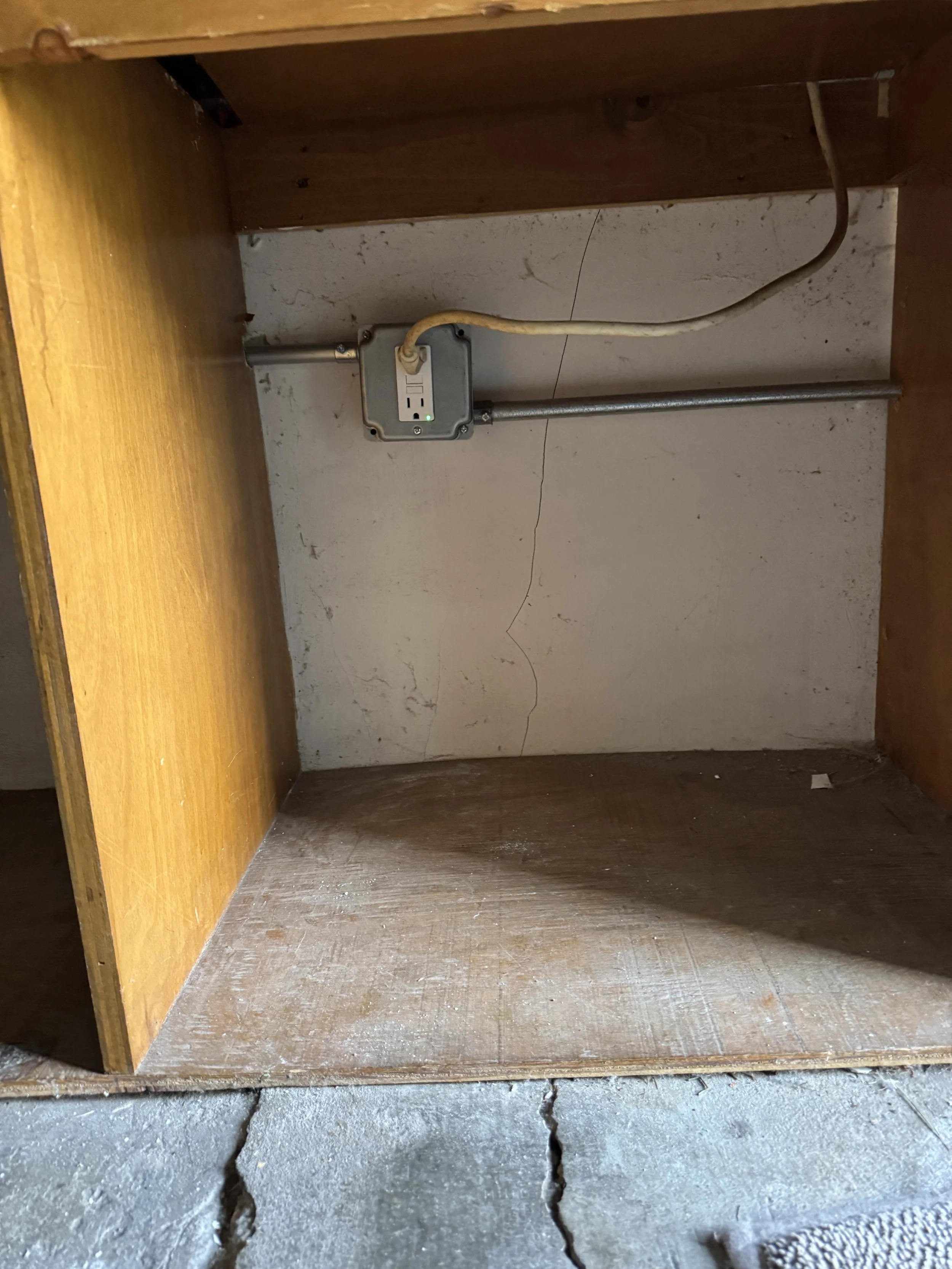 Junction box and cable in an unfinished space beneath a Norfolk, VA house