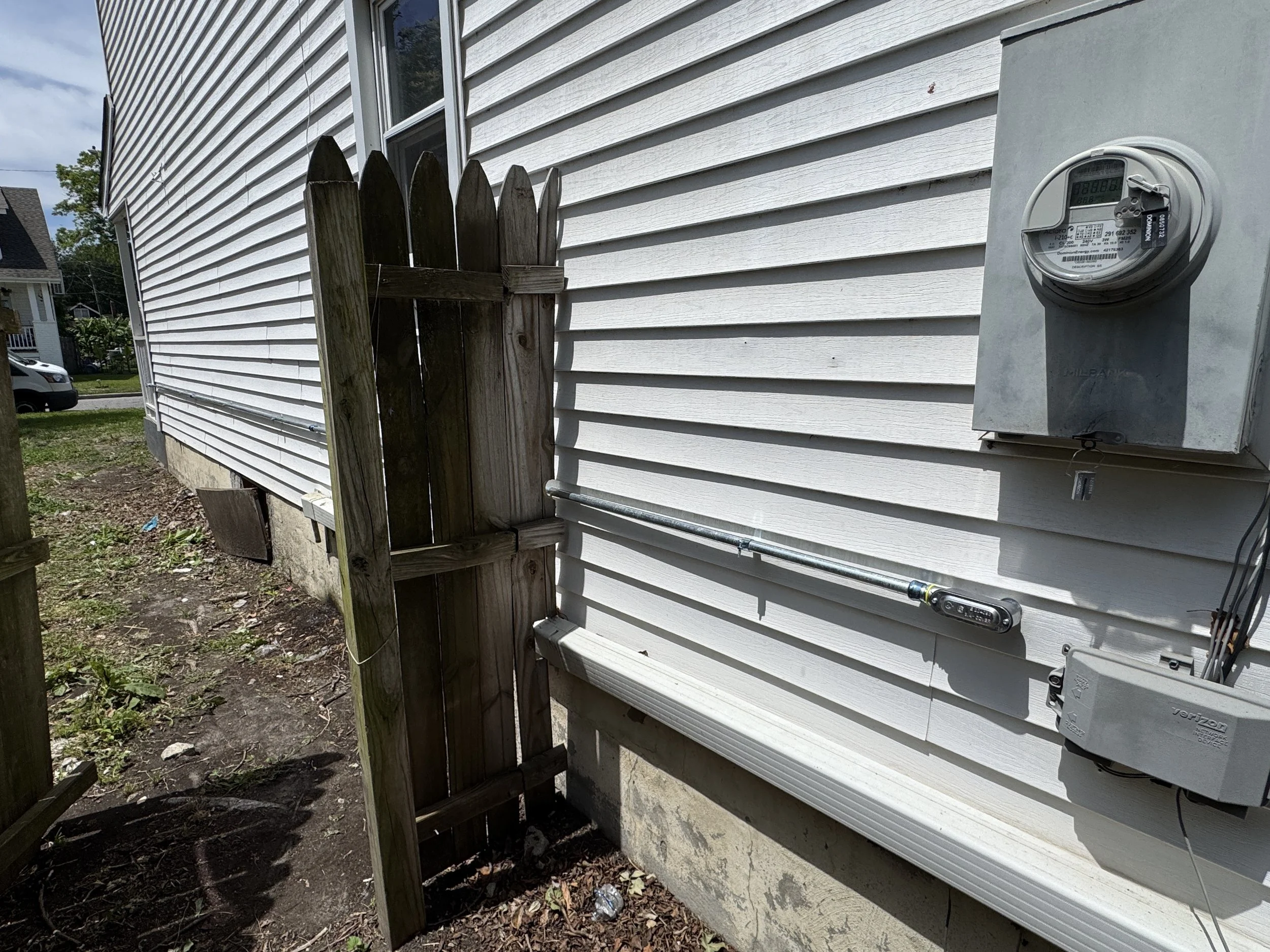 Meter base beside storm-damaged fencing at a Chesapeake, VA home
