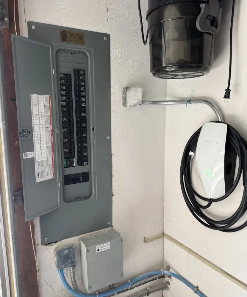 Panel and EV charger on a garage wall after a Suffolk, VA project