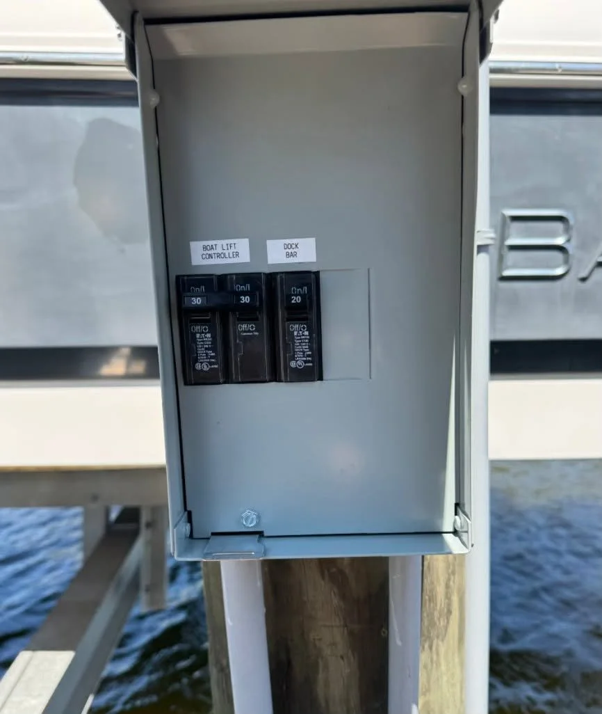 Dock disconnect on a piling with the boat lift breaker labeled, water below
