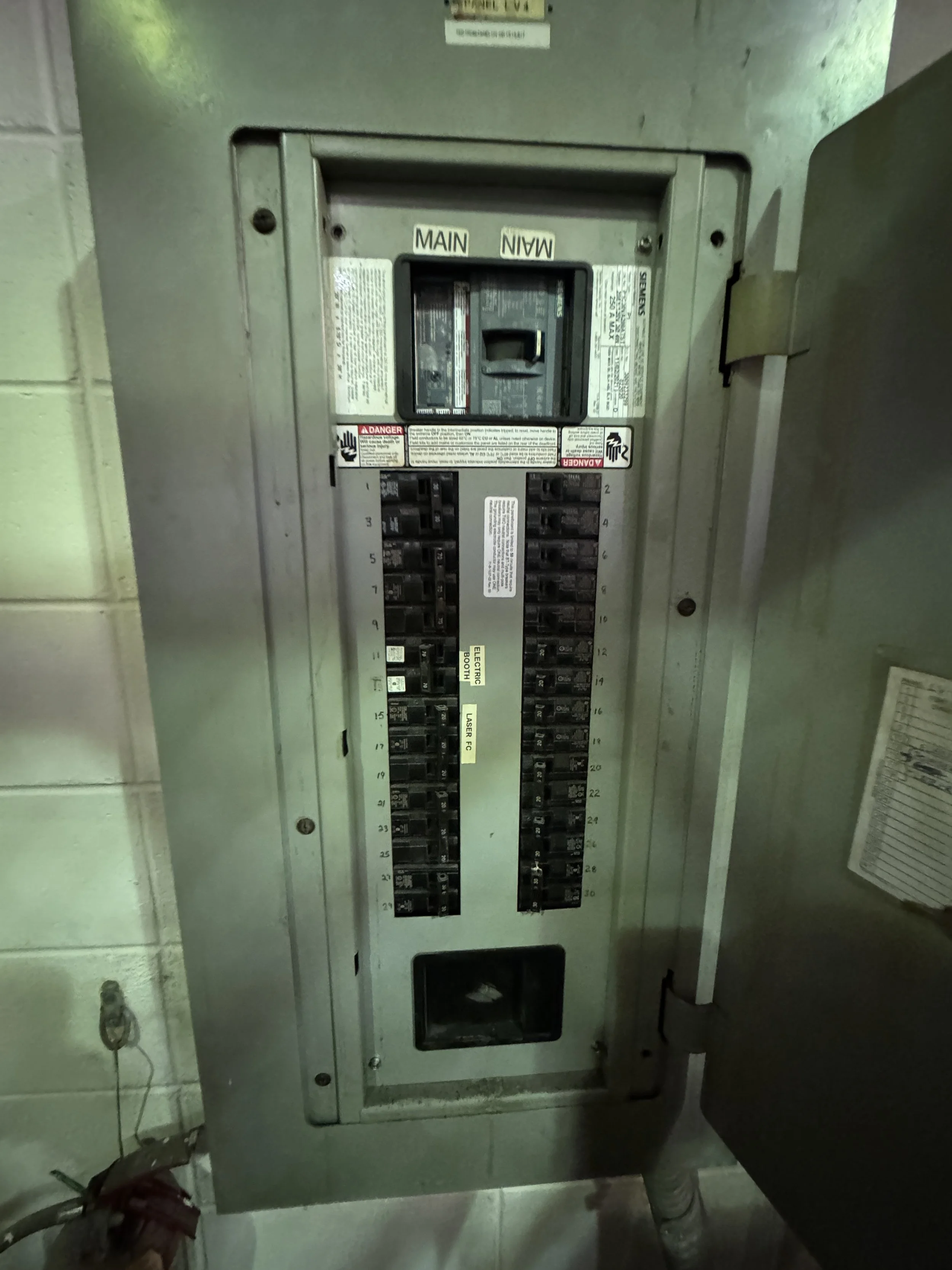 Breaker panel with its door open in a commercial building, breakers ready to be labeled