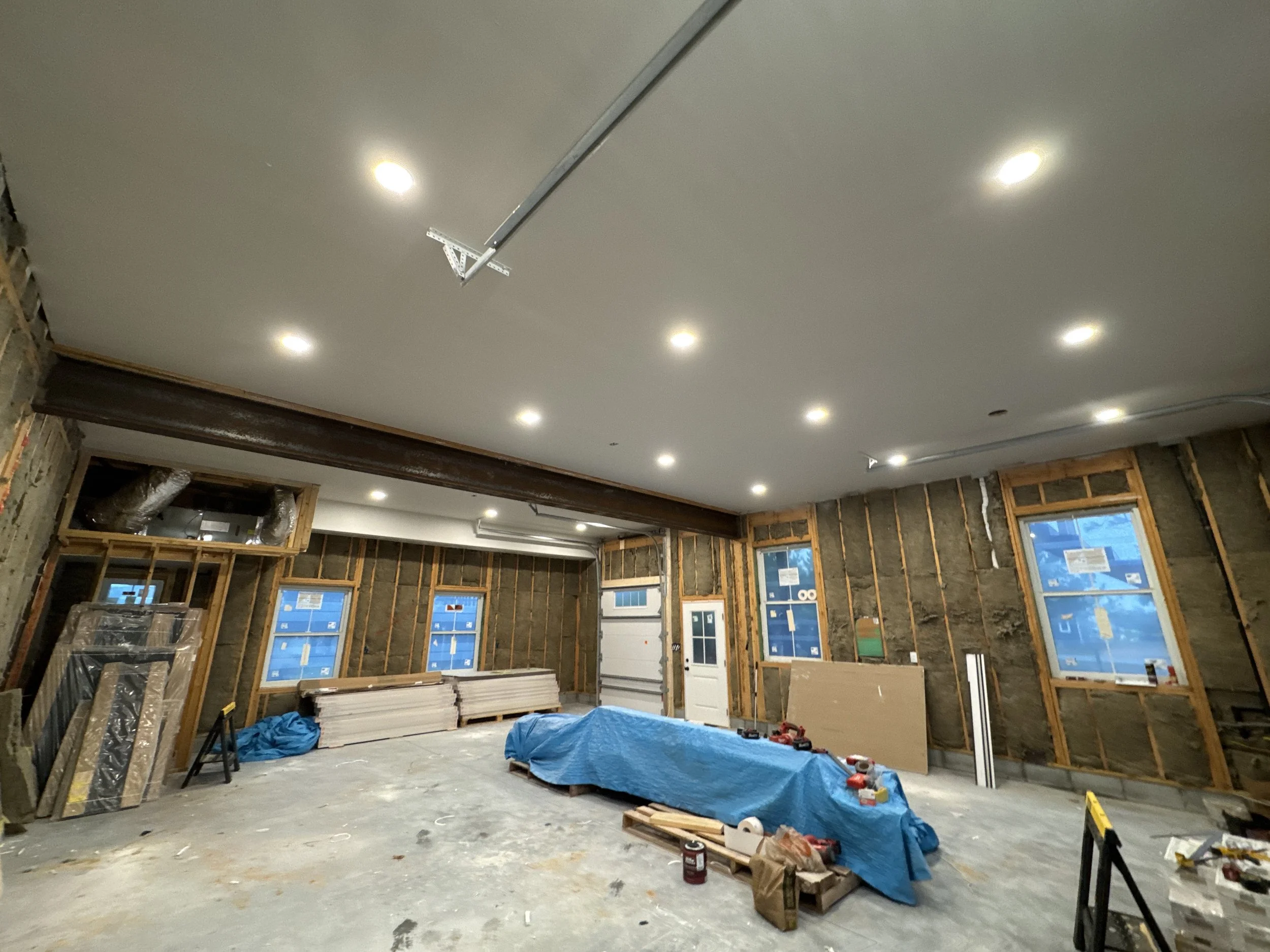 Recessed lighting wired into the ceiling of a room under construction
