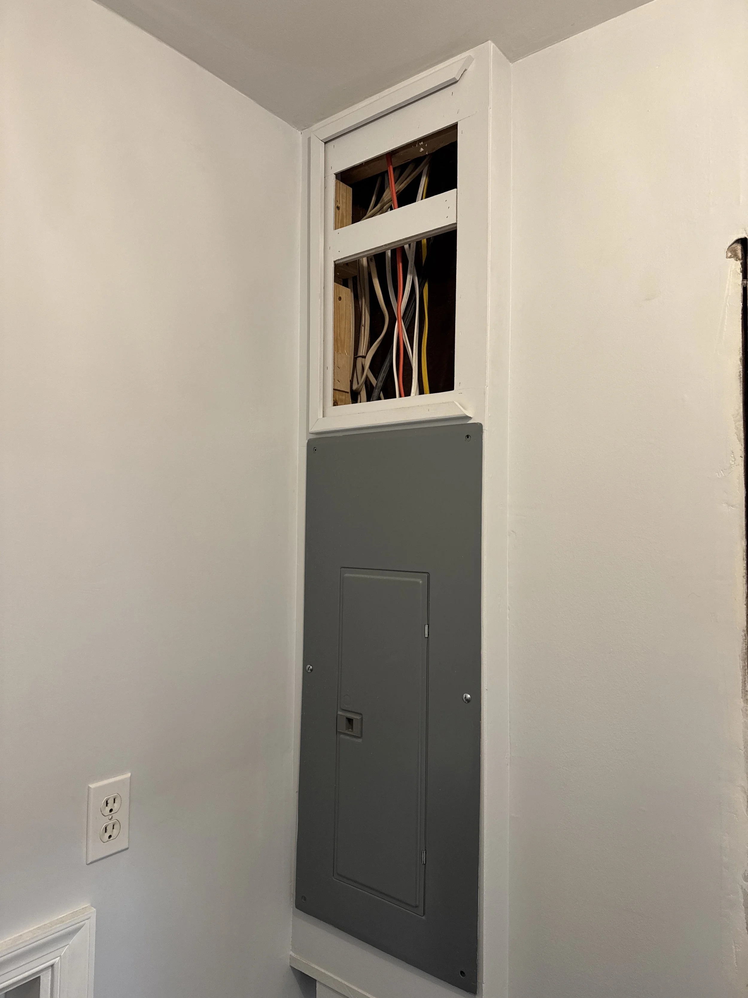Replacement panel set into the wall of a Chesapeake, VA home, with the new circuit cables above it