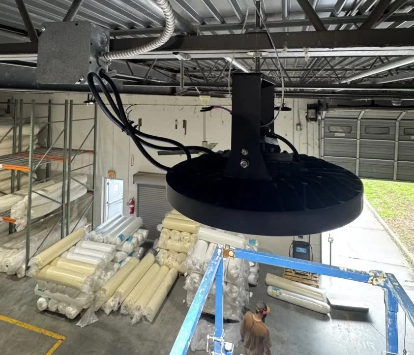 Castles Electrical electrician on a lift fitting a fixture in a commercial building